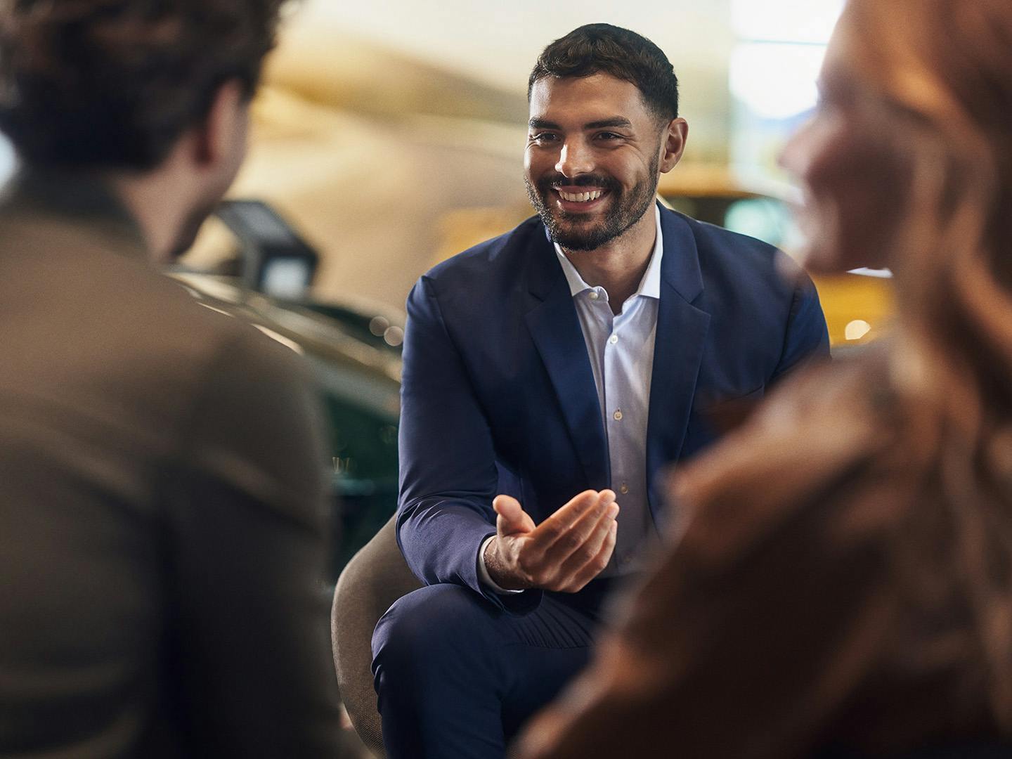 A Porsche employee advises a couple at the Porsche Center.