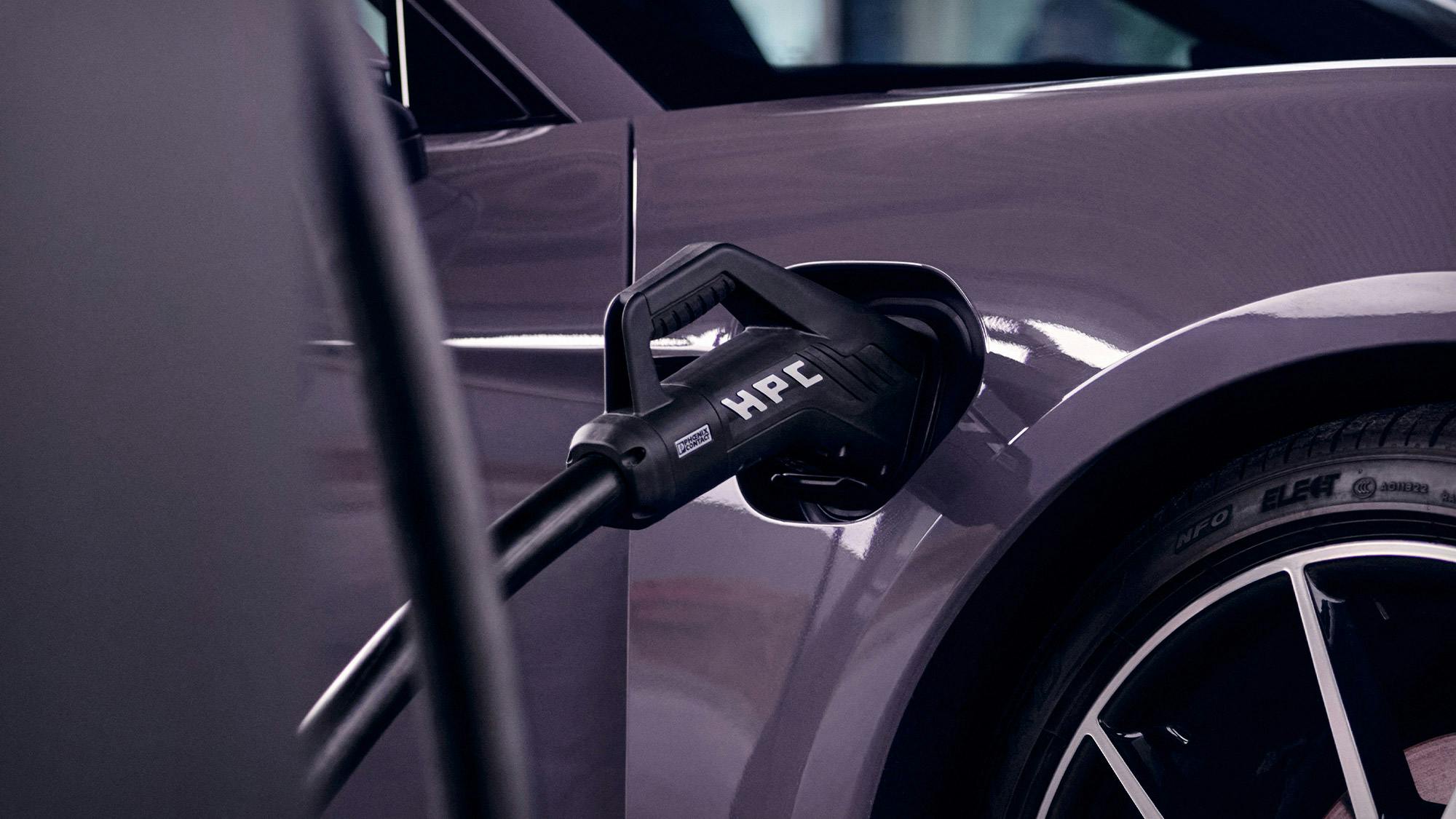 Un câble de recharge branché sur une Porsche Taycan violette.