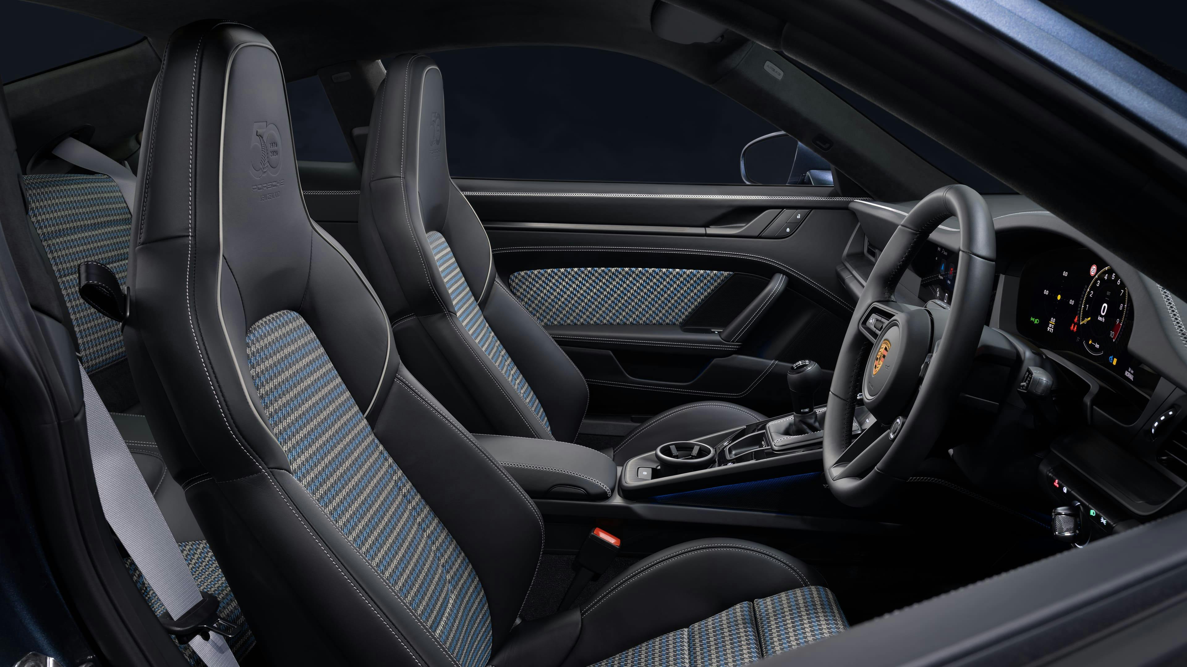 Sports car interior with patterned fabric sports seats, leather trim, and a manual gear lever.