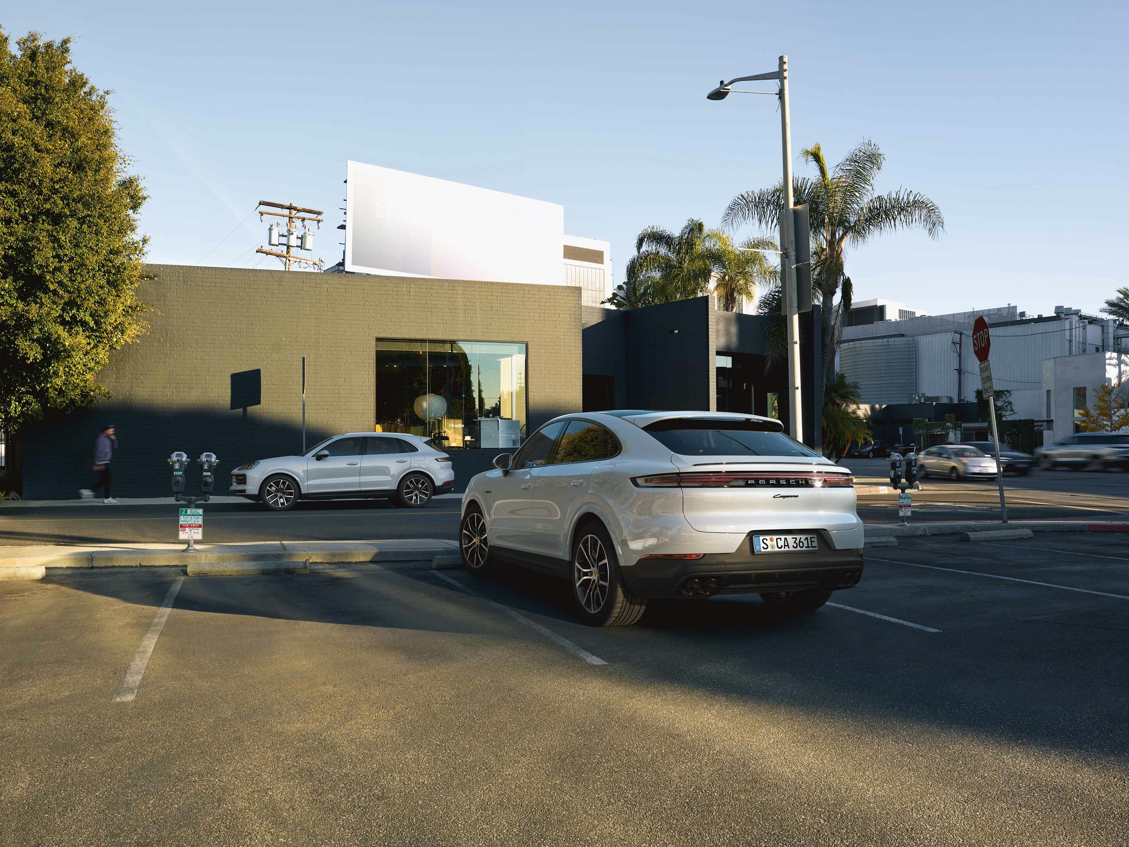 Twee Porsche Cayenne modellen op straat geparkeerd.