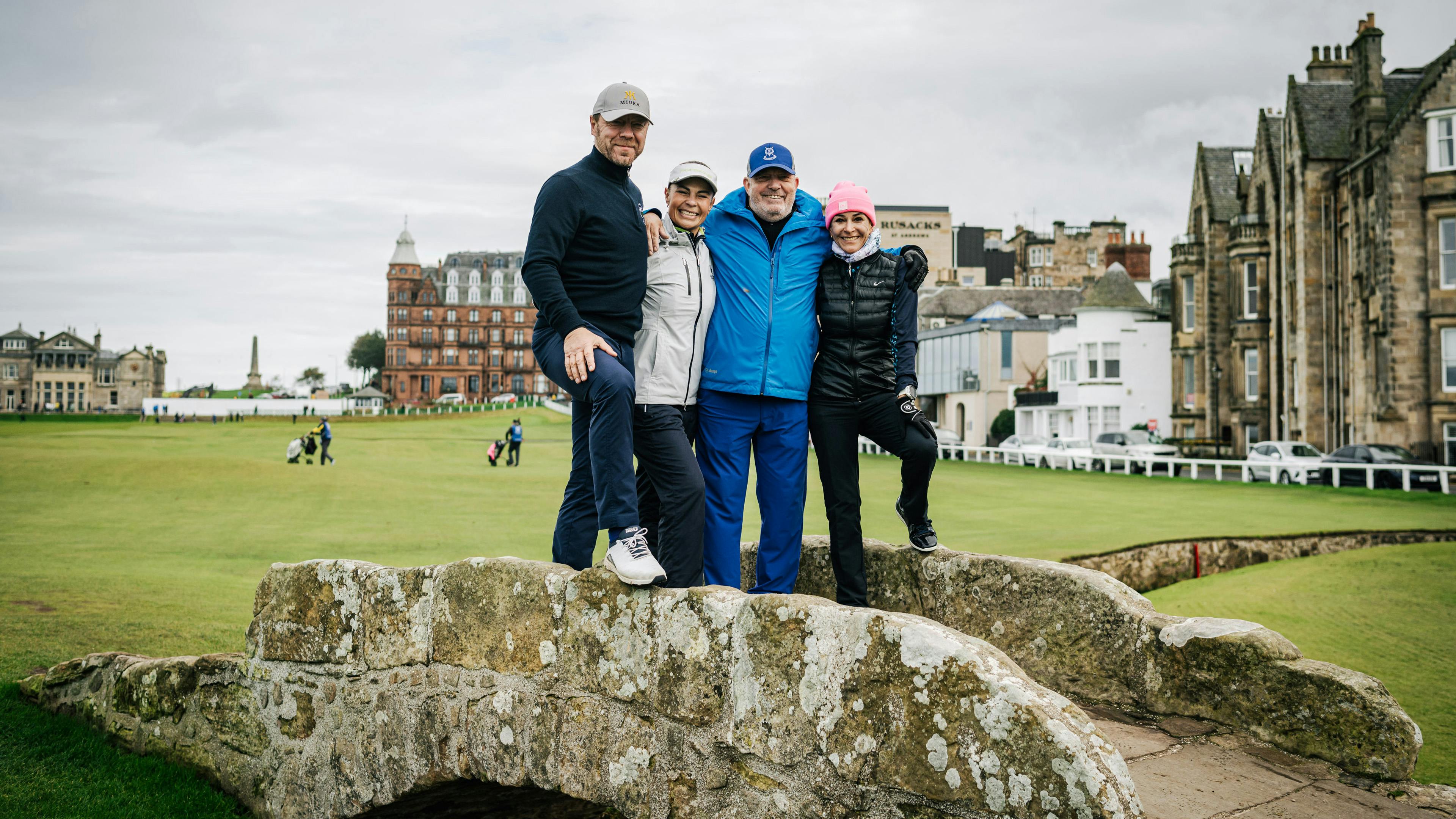 Golf fans posing on a historic green.