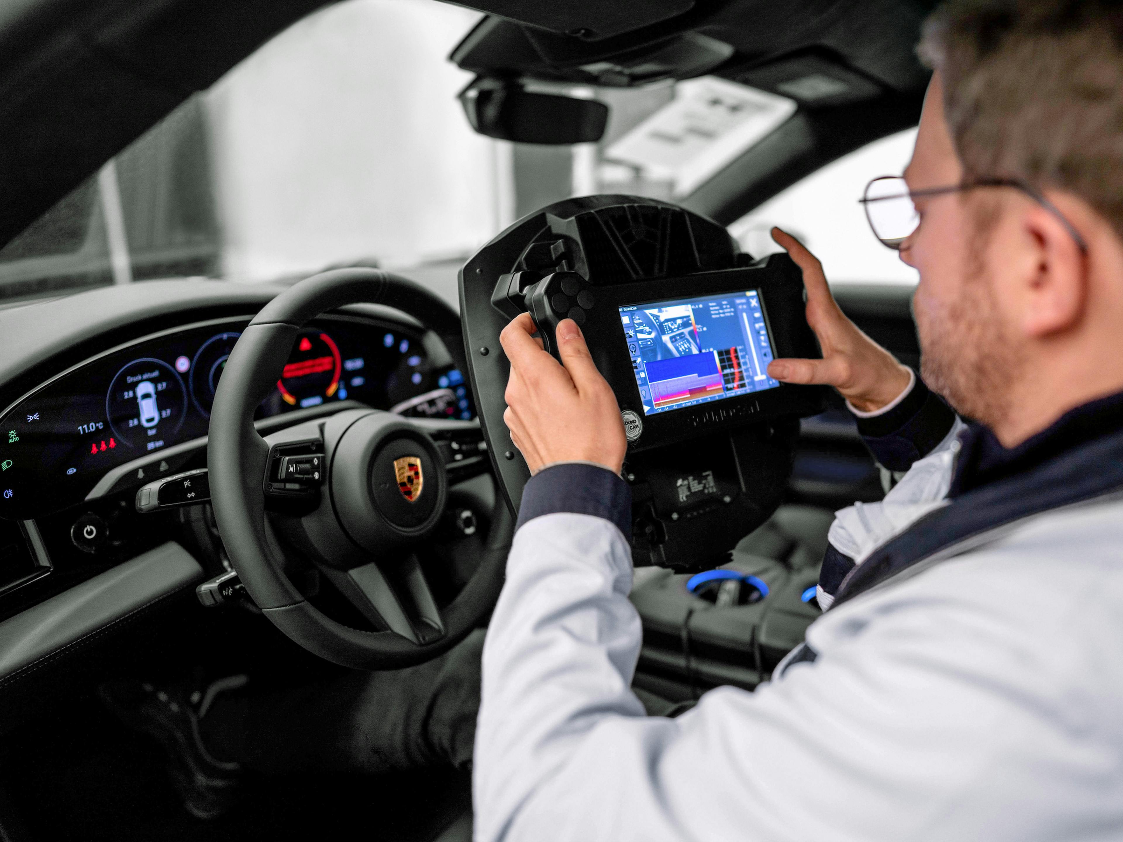Ein Porsche Mitarbeiter probiert eine neue VR-Technologie in dem Fahrzeug aus.
