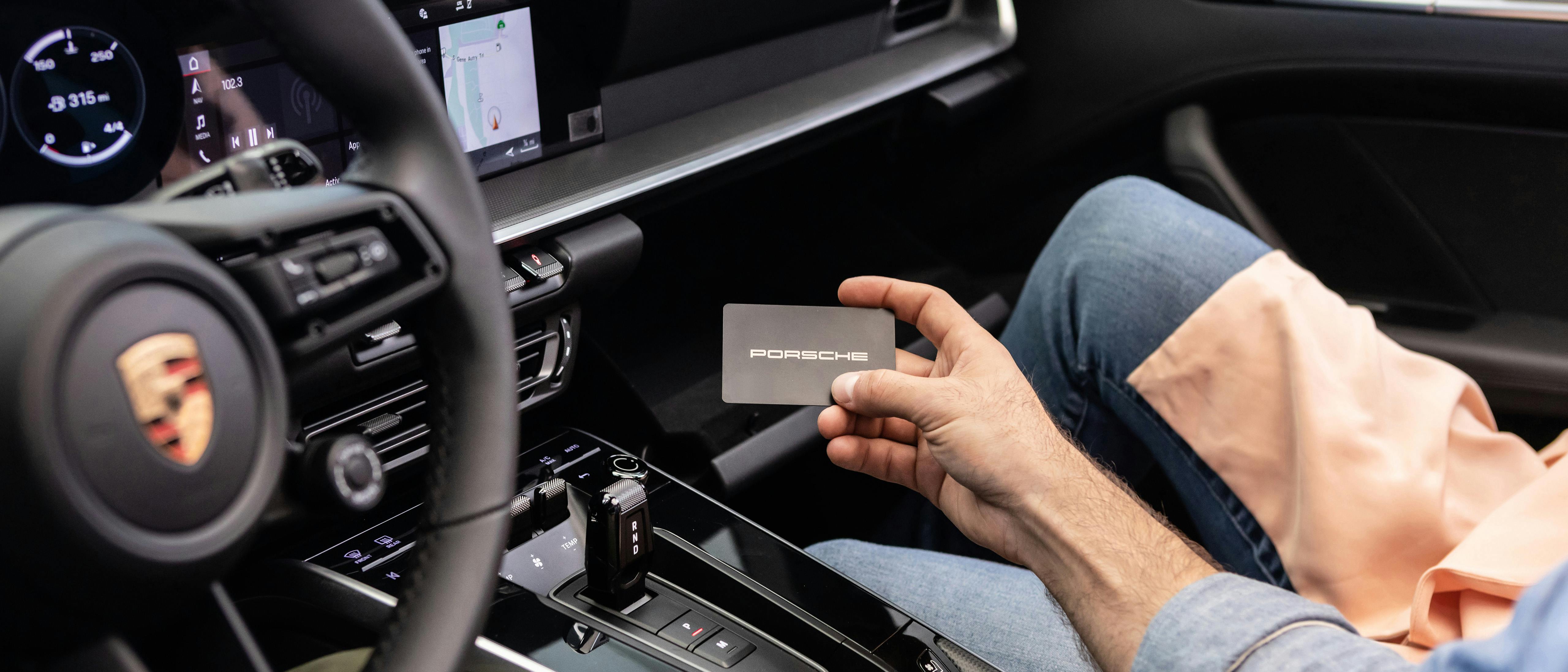 Porsche Auto Insurance card being placed in glove box.