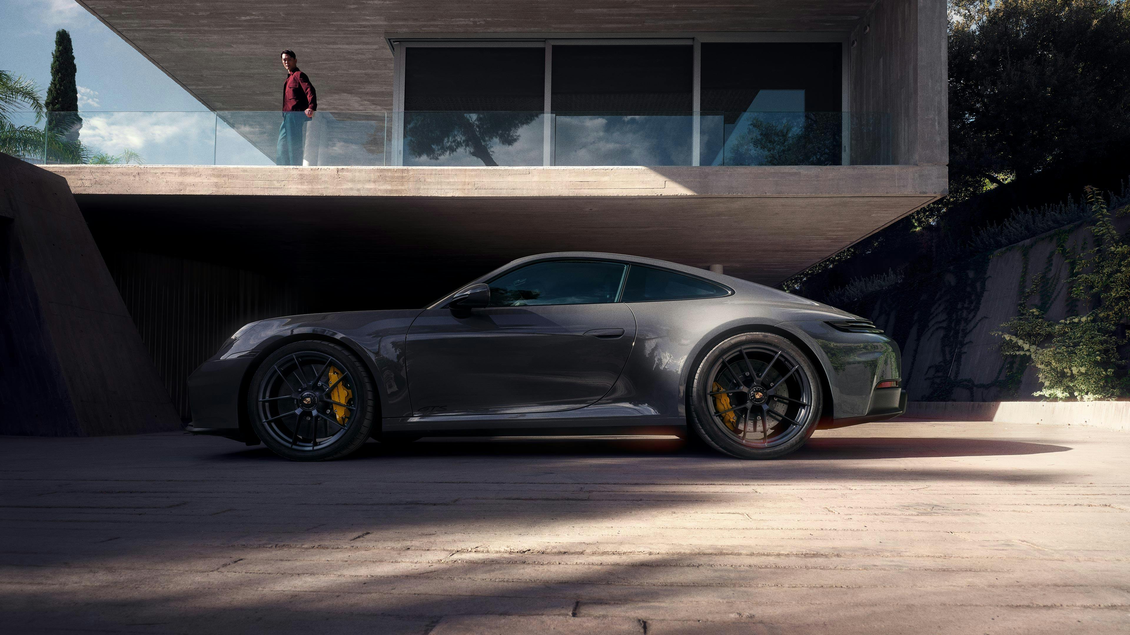 Une Porsche 911 GTSgarée devant une villa d'architecte.