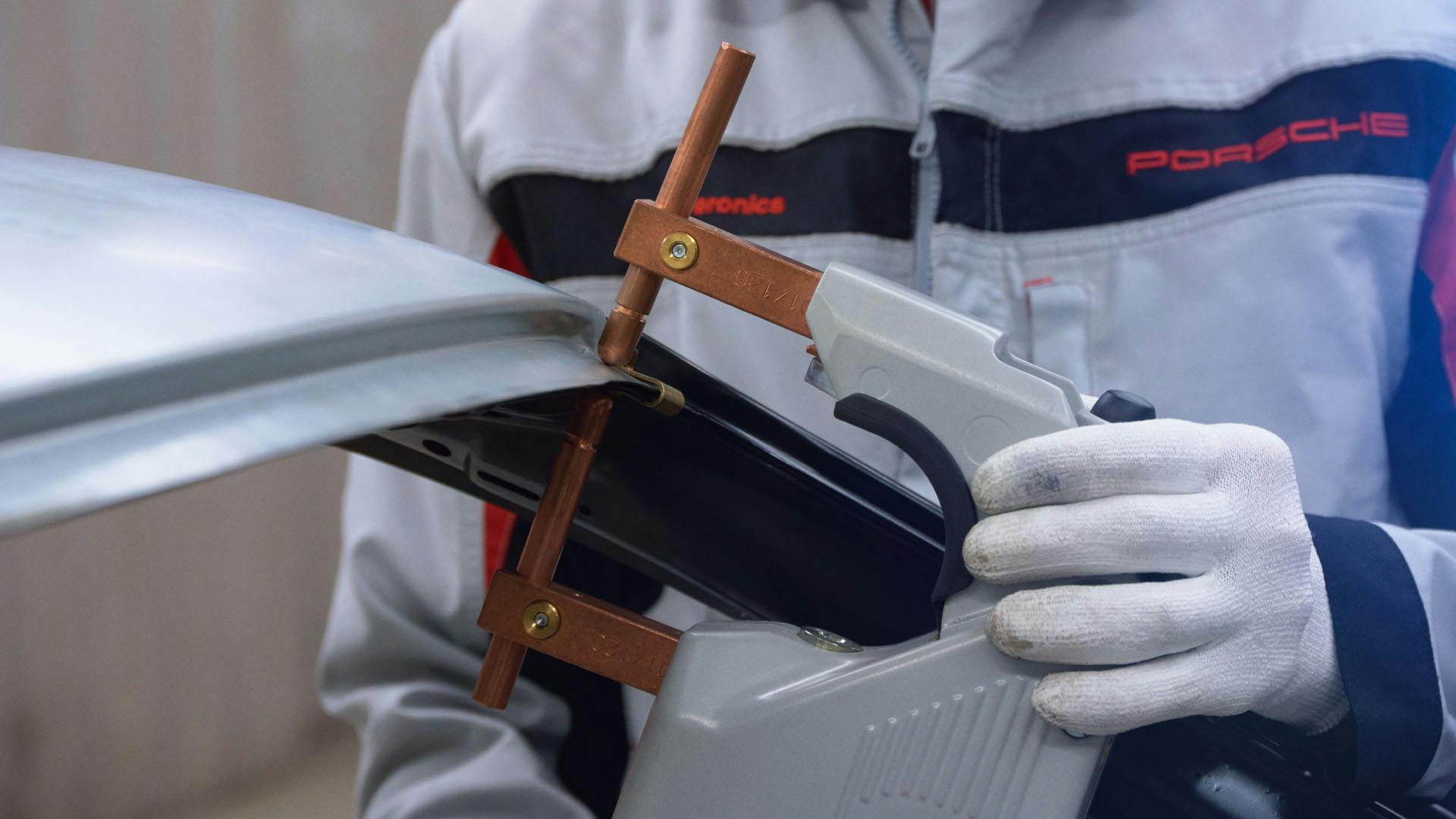 Porsche employee attaches  clamp to body-in-white