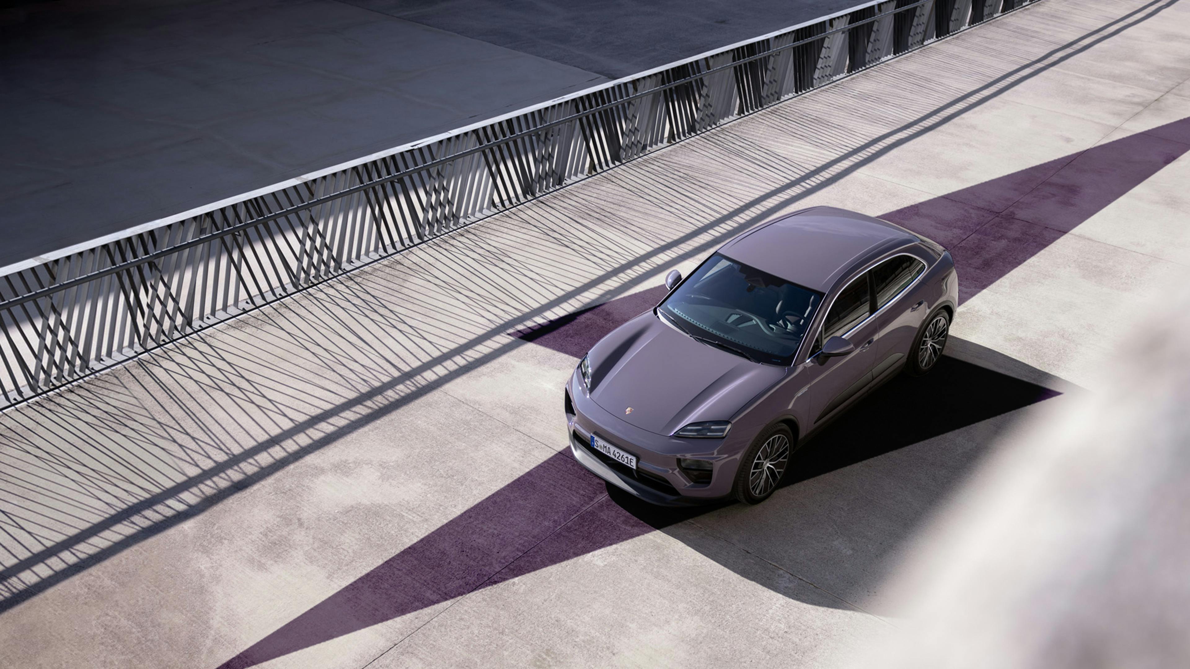 Un Porsche Macan 4 Eléctrico de color morado pasa sobre un puente.