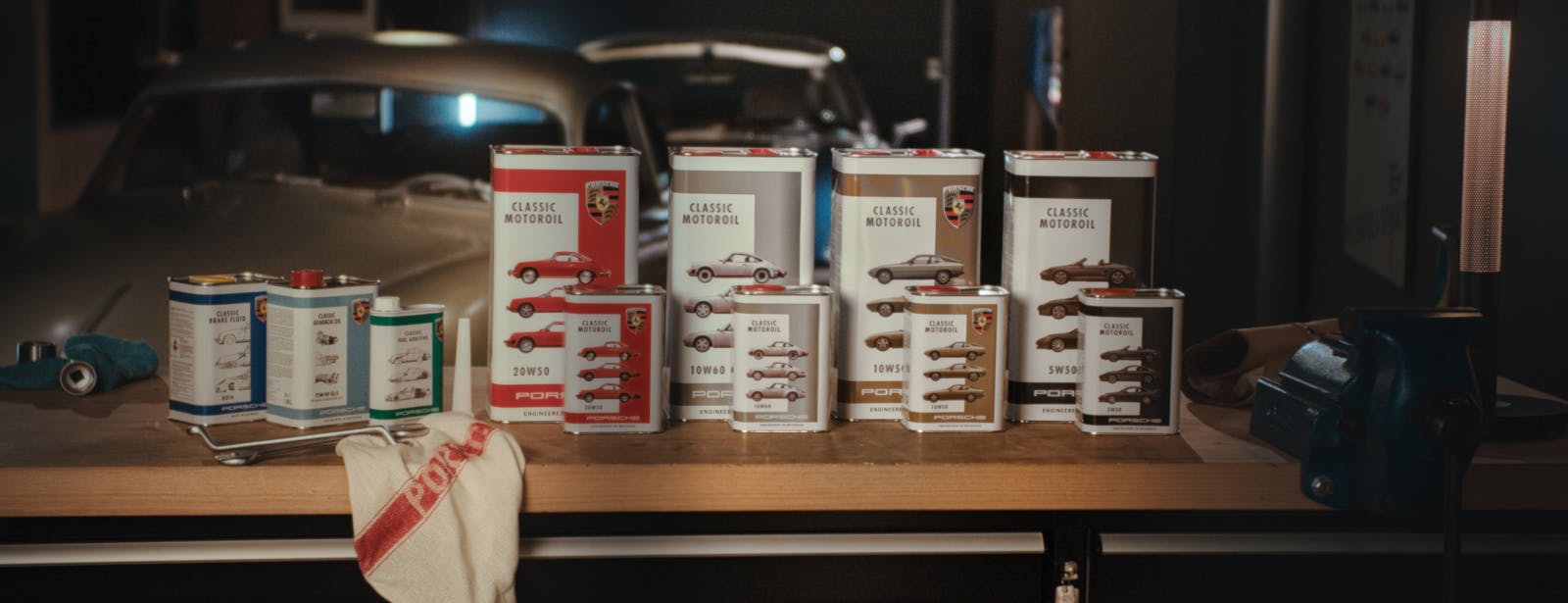 Porsche Classic Motoroil cans standing on a table in a garage.