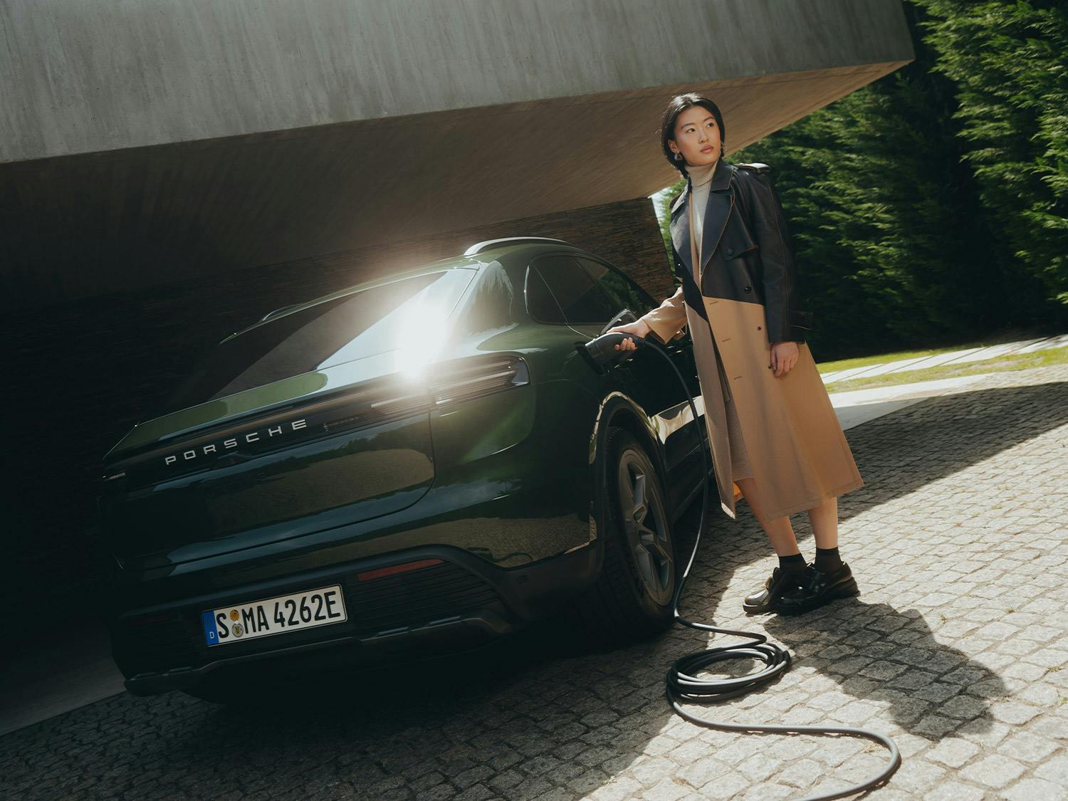 A Porsche Macan 4S and a Porsche Taycan Turbo Cross Turismo in front of a villa.