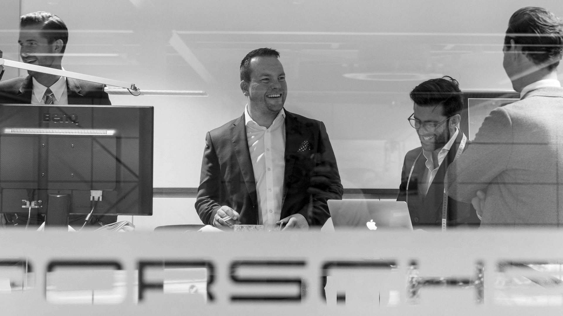 Schwarz-weiss Bild, welches ein Porsche Büro mit Mitarbeitern zeigt.