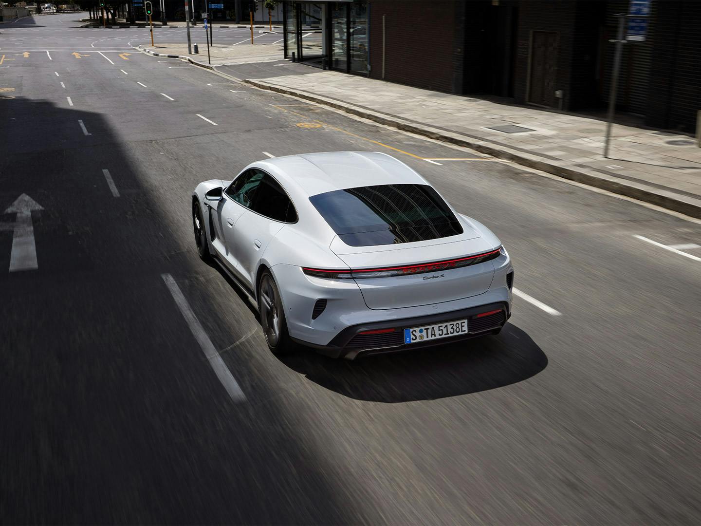 Taycan Turbo S driving on the road through an urban environment.