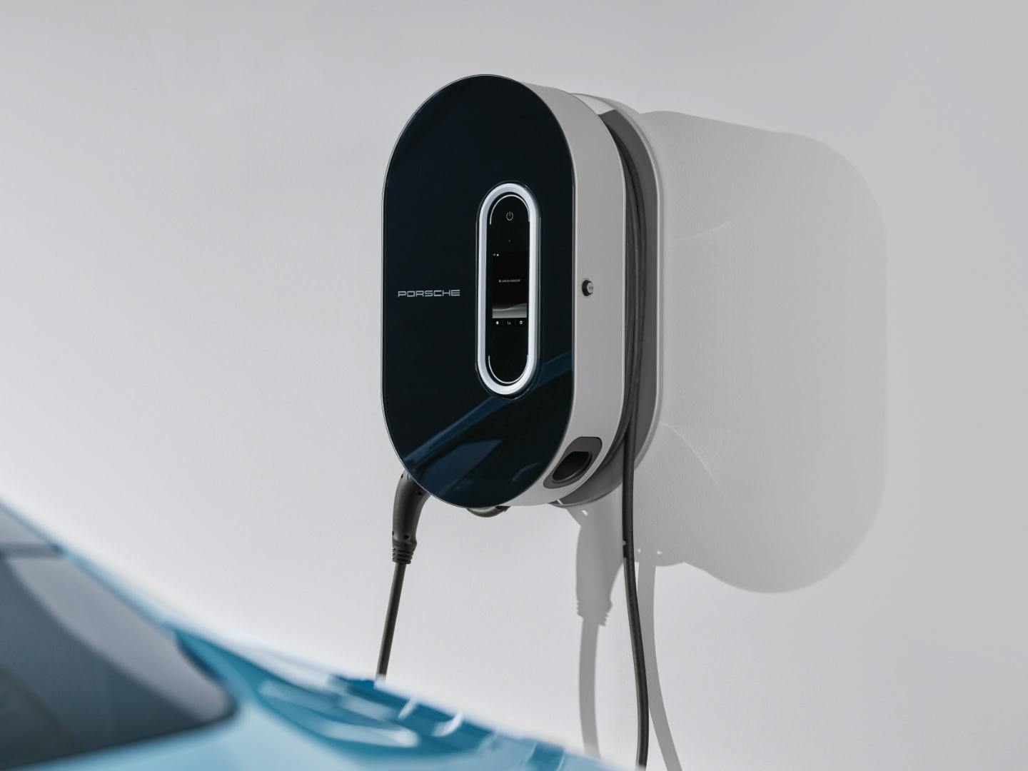 A black and white Porsche wall box is mounted on a white wall.
