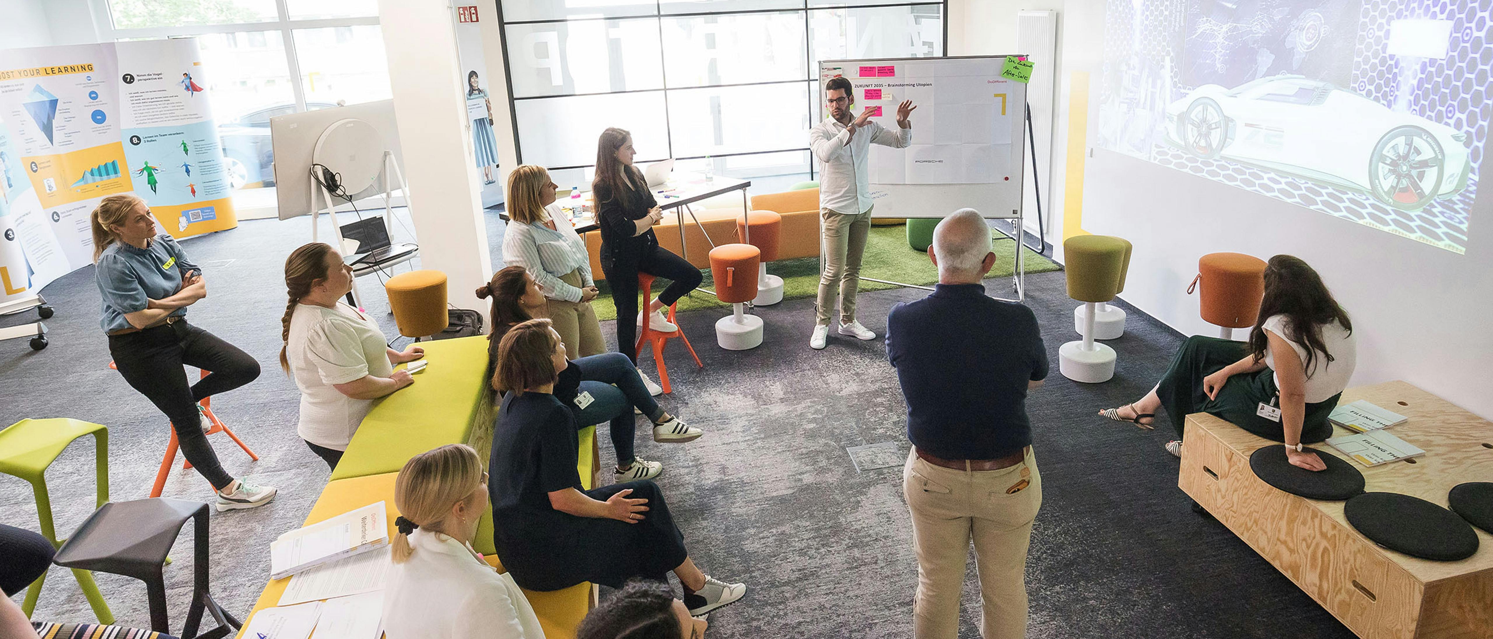 Viele Porsche Mitarbeiter tauschen sich in dem innovativen Porsche LearningLab aus.