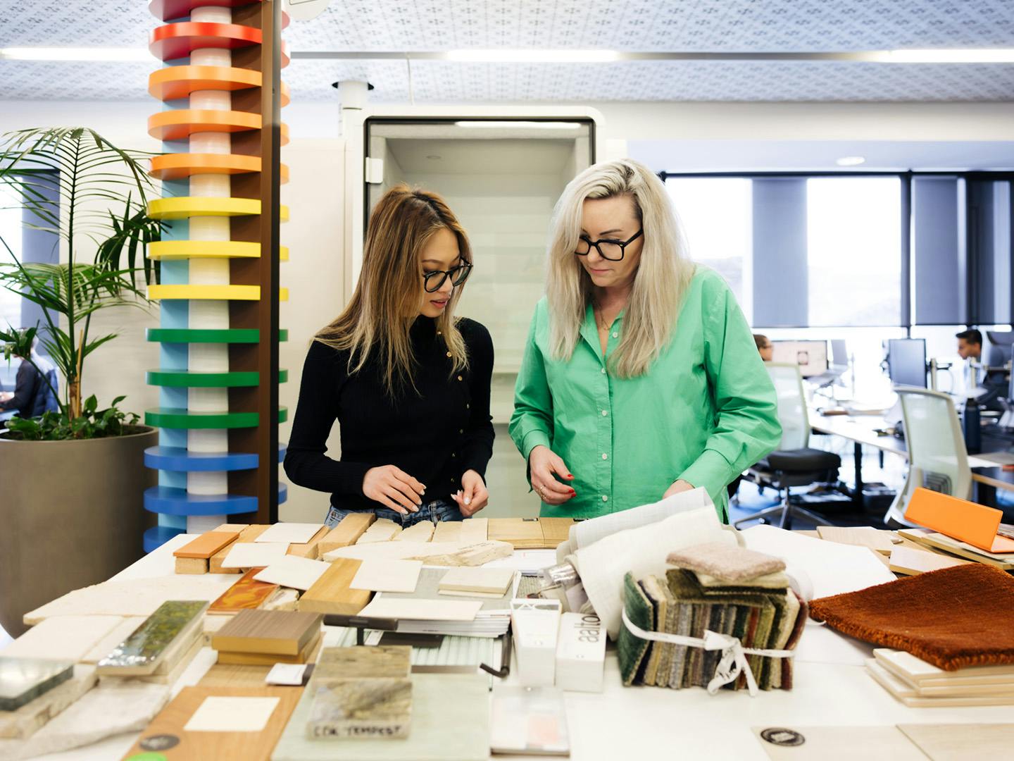two women standing looking at fabric samples
