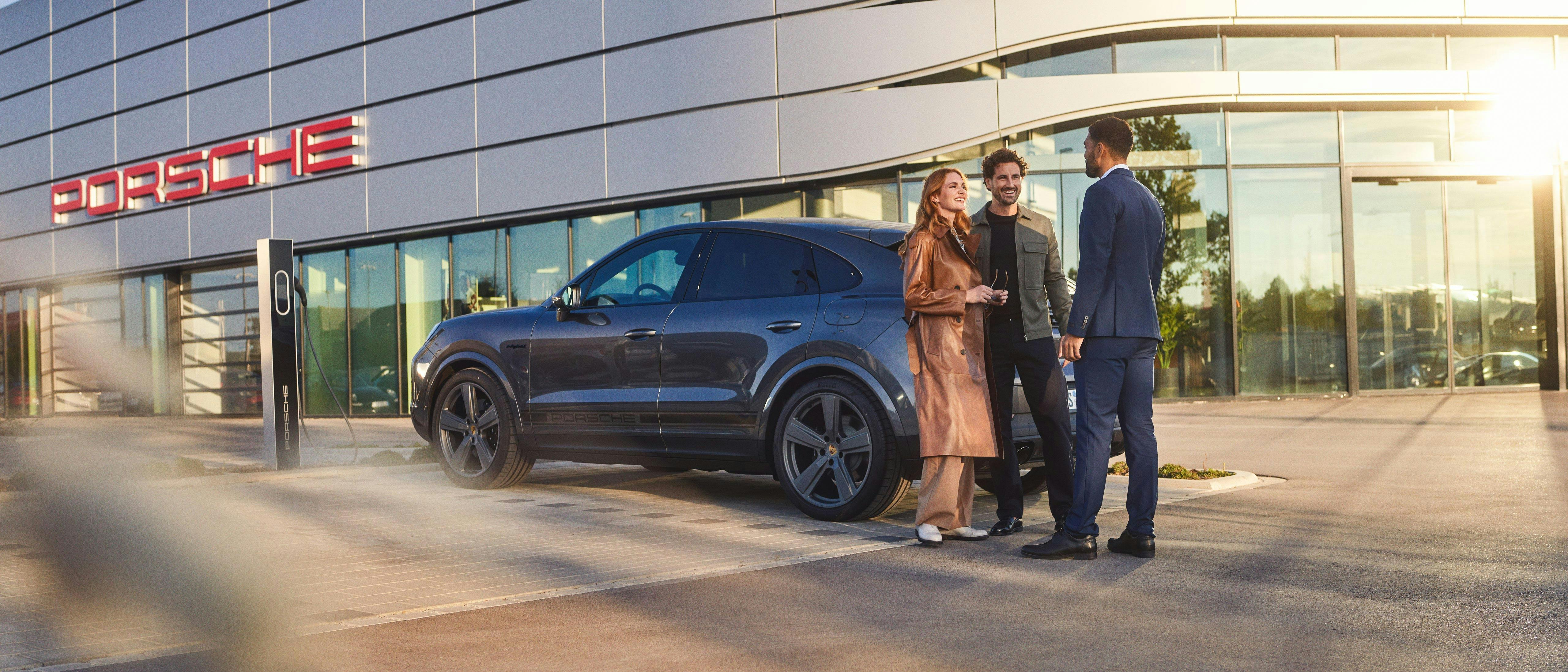 Family and Porsche employee standing outside Porsche Centre