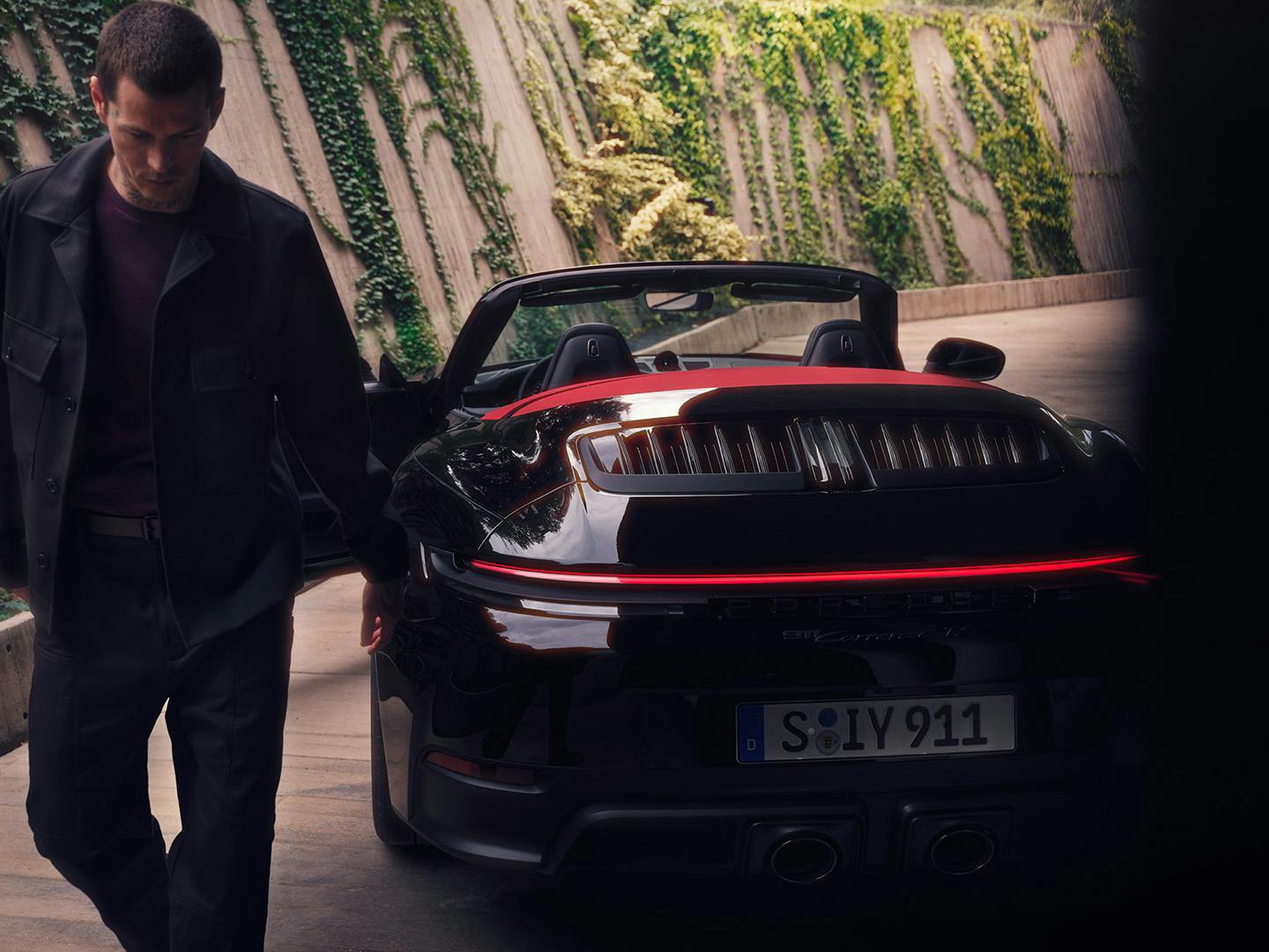 Man walking away from a 911 Carrera GTS Cabriolet.