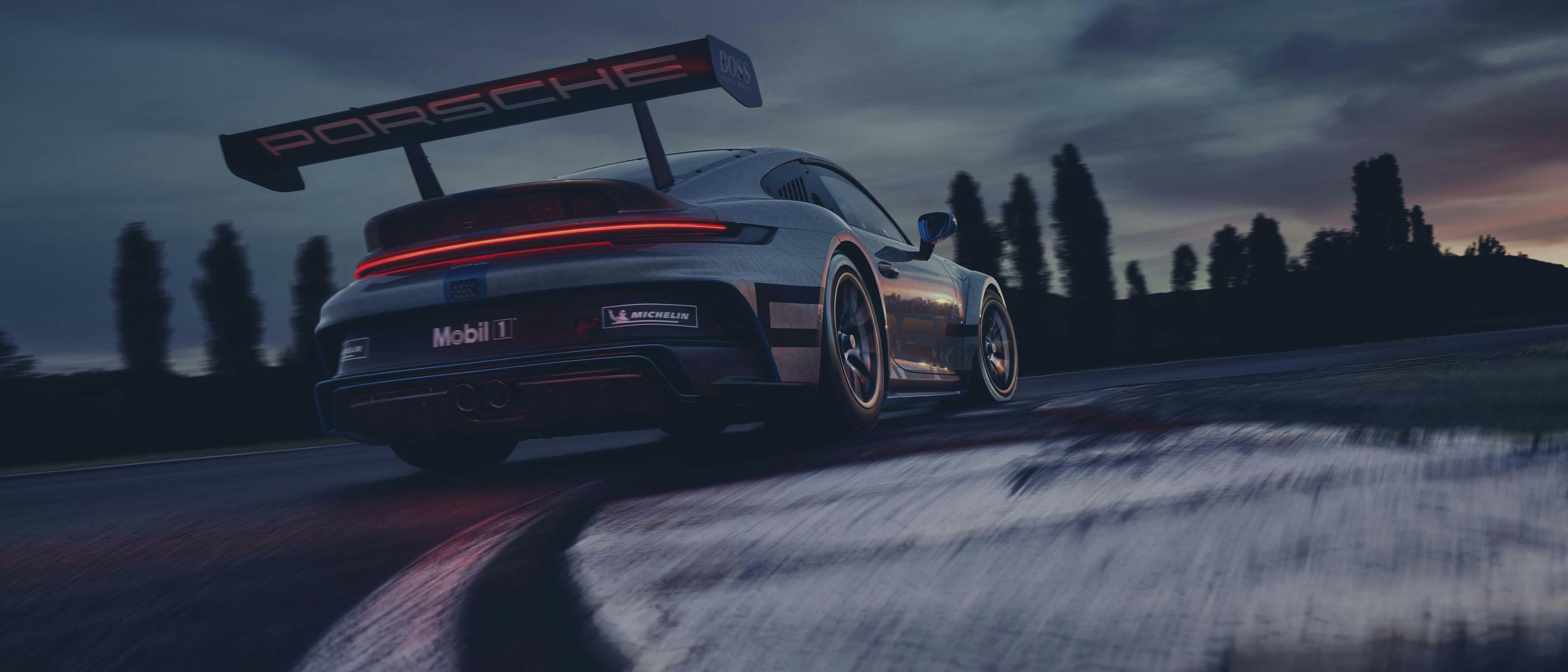 En grå Porsche 911 på racingbanan en mörk höstdag.