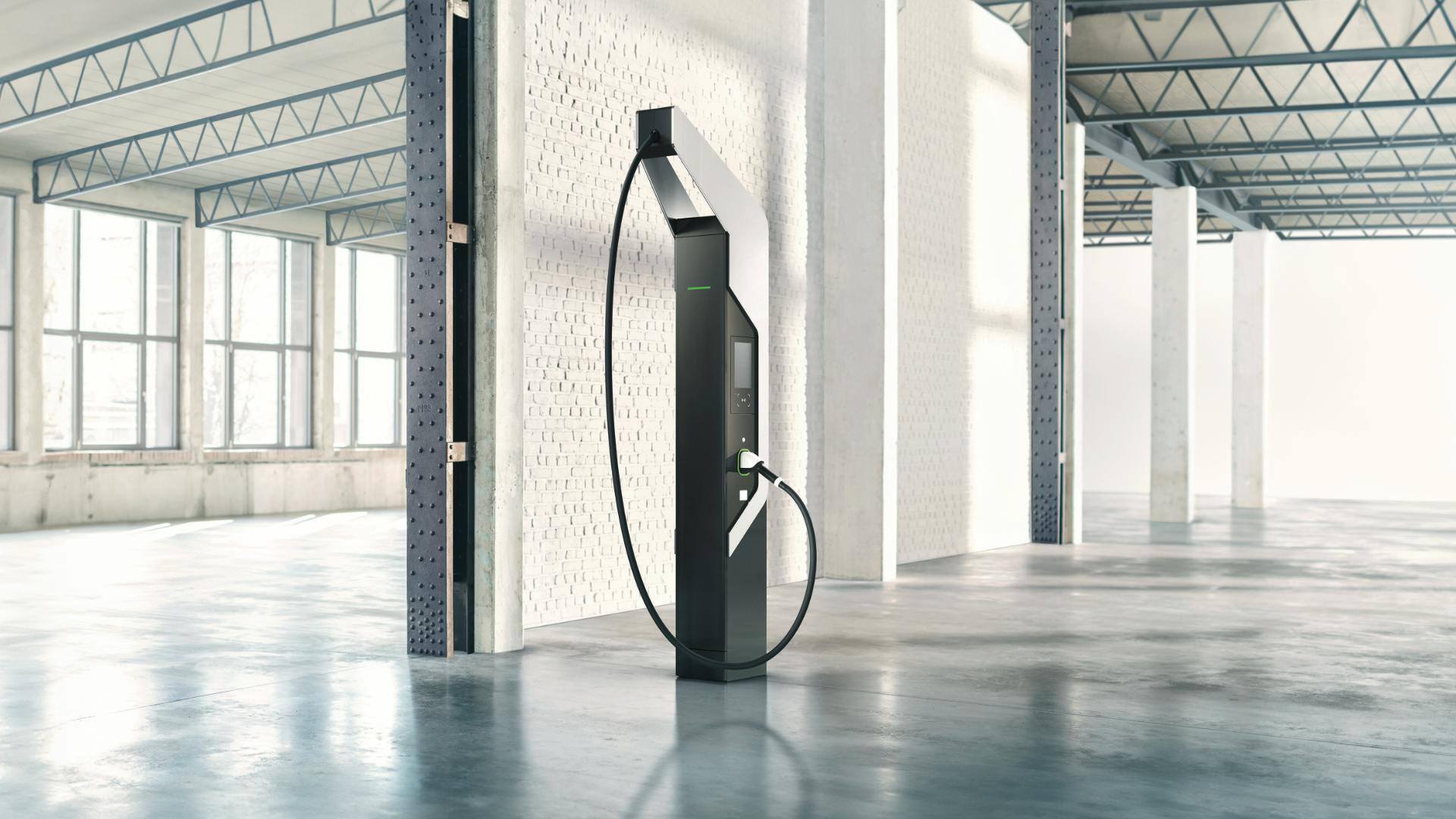 A black Porsche Turbo Charger fast charging station in a light-flooded hall.