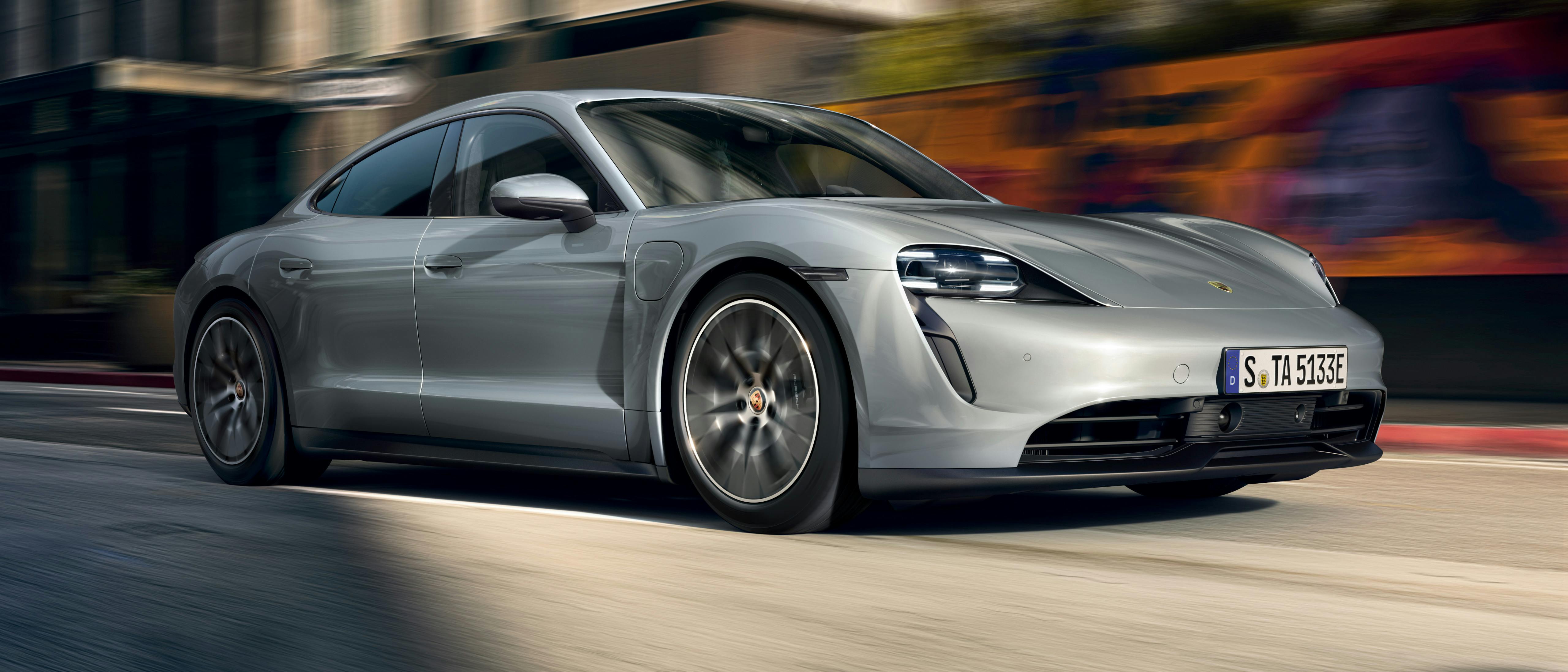 Porsche Approved Pre-Owned Taycan driving in a city.