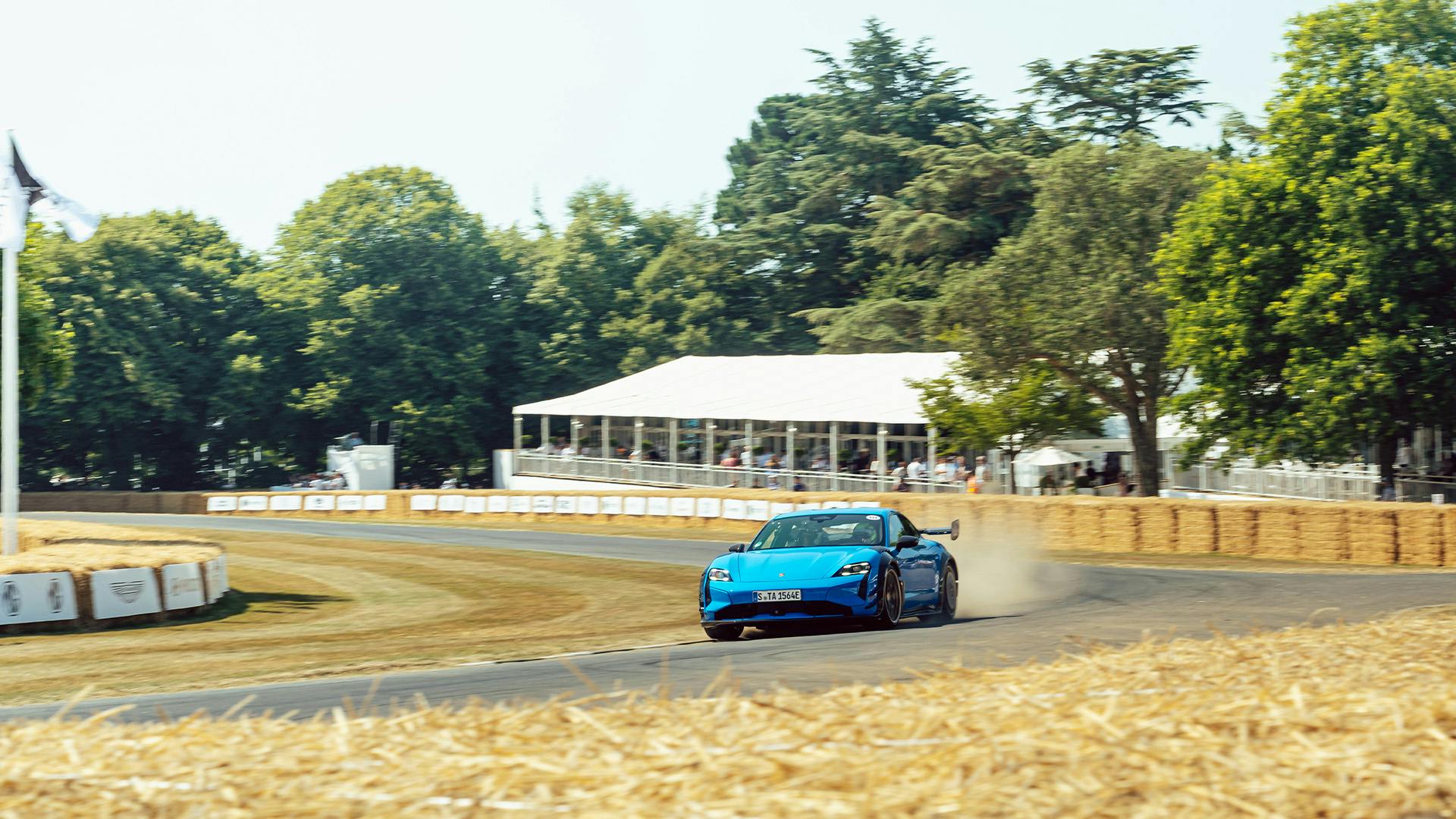 Porsche cornering on the Goodwood hillclimb, hay bales lining the track.