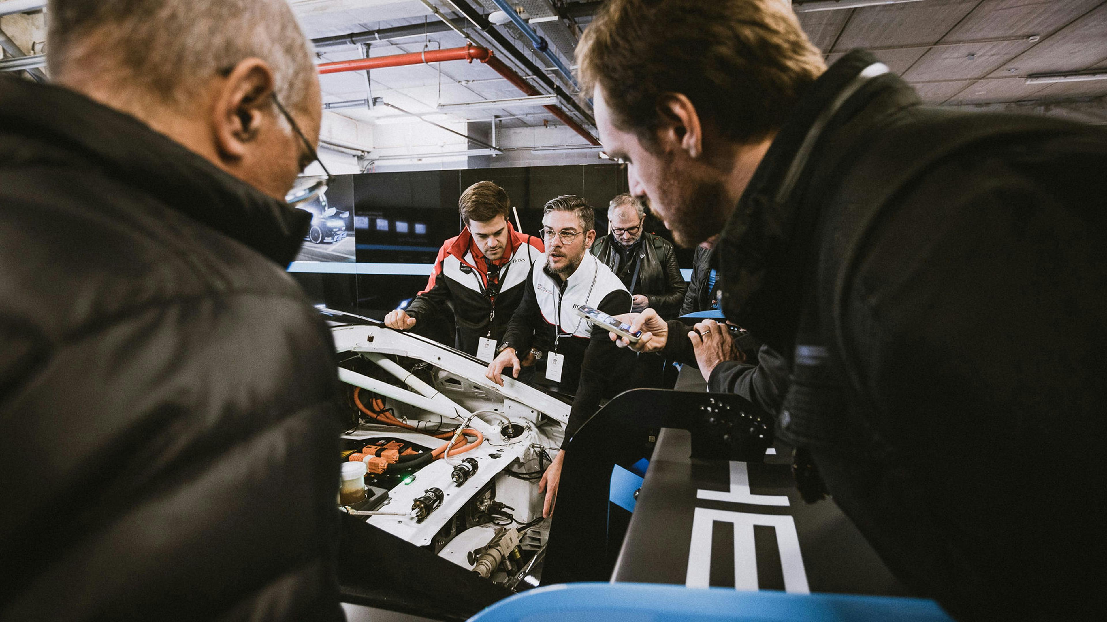 Porsche enthusiasts working at an engine.