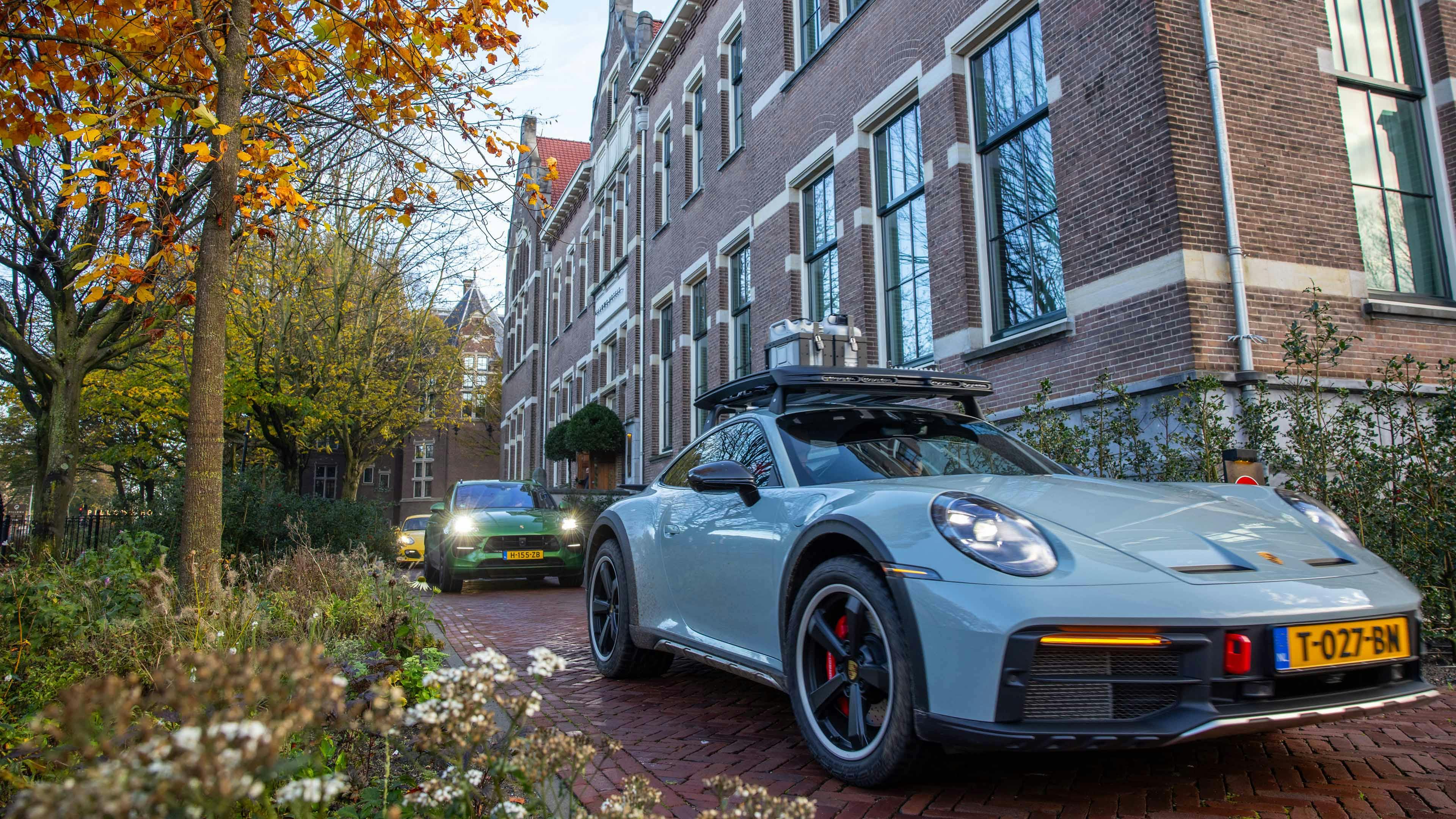 Porsche 911 Dakar en diverse andere Porsche rijders voor een luxe hotel in Amsterdam tijdens de Level Yellow Experience 2024