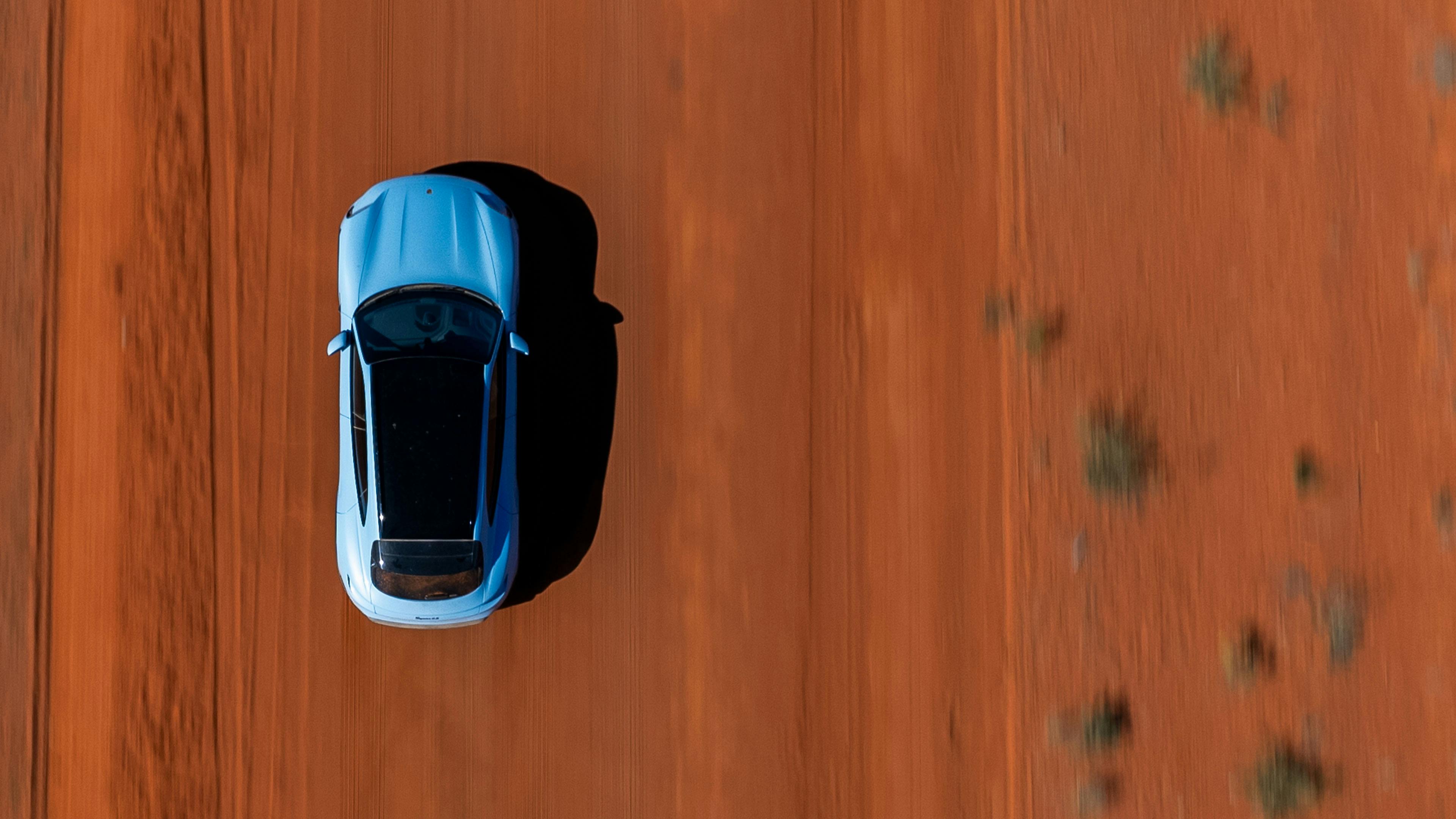 Aerial view of Porsche Taycan in a red desert