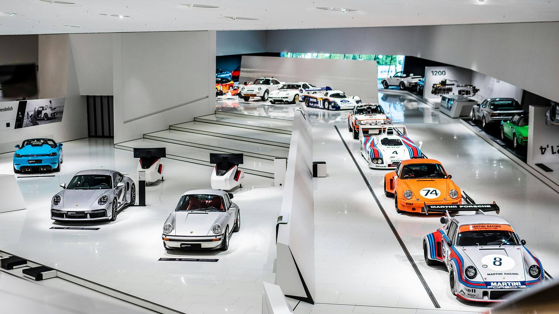 Interior view of the Porsche Museum with several exhibited Porsche cars