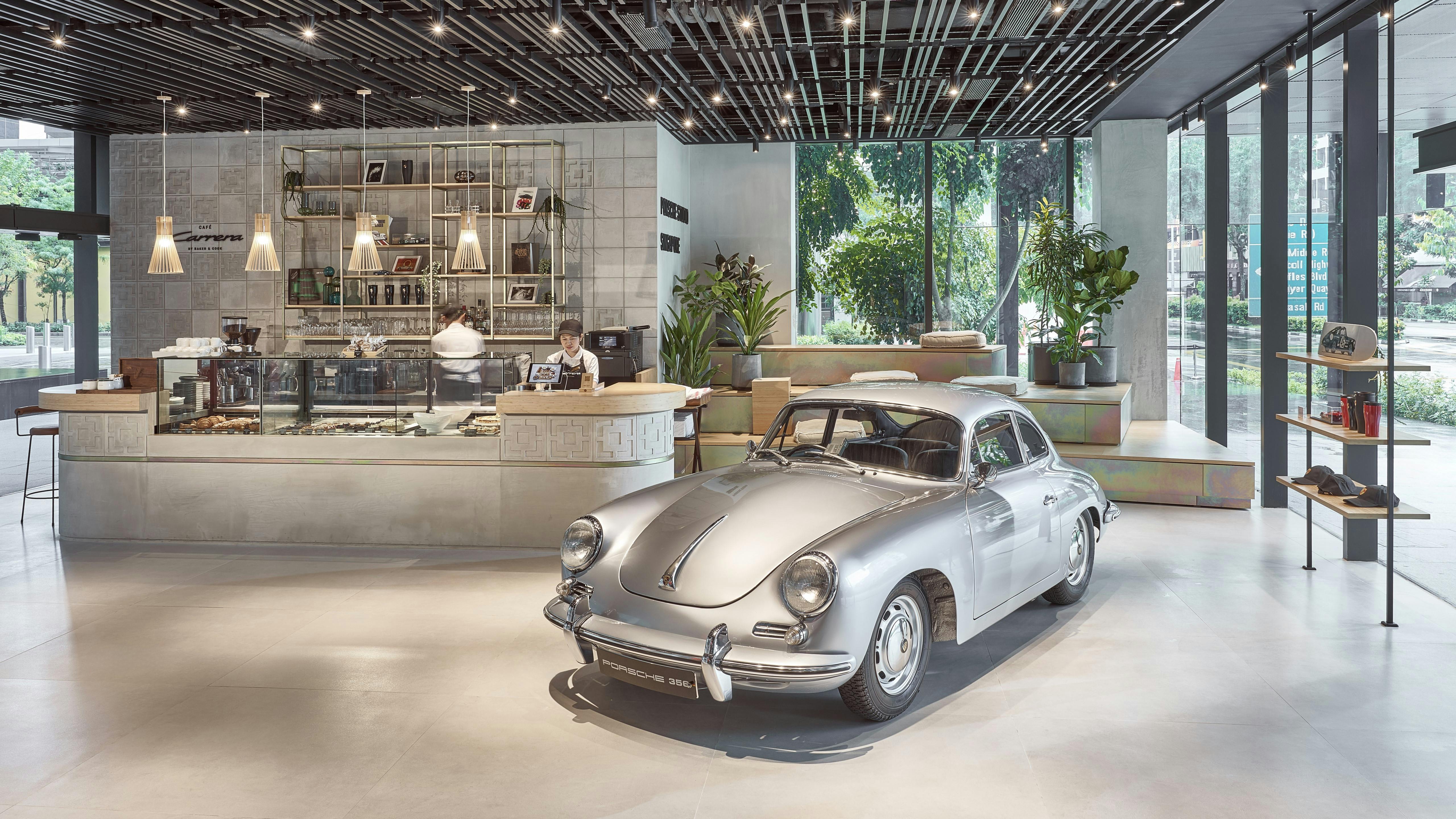 General view of Porsche Studio Singapore, with a silver Porsche 356 Coupe parked next to Café Carrera by Baker & Cook.