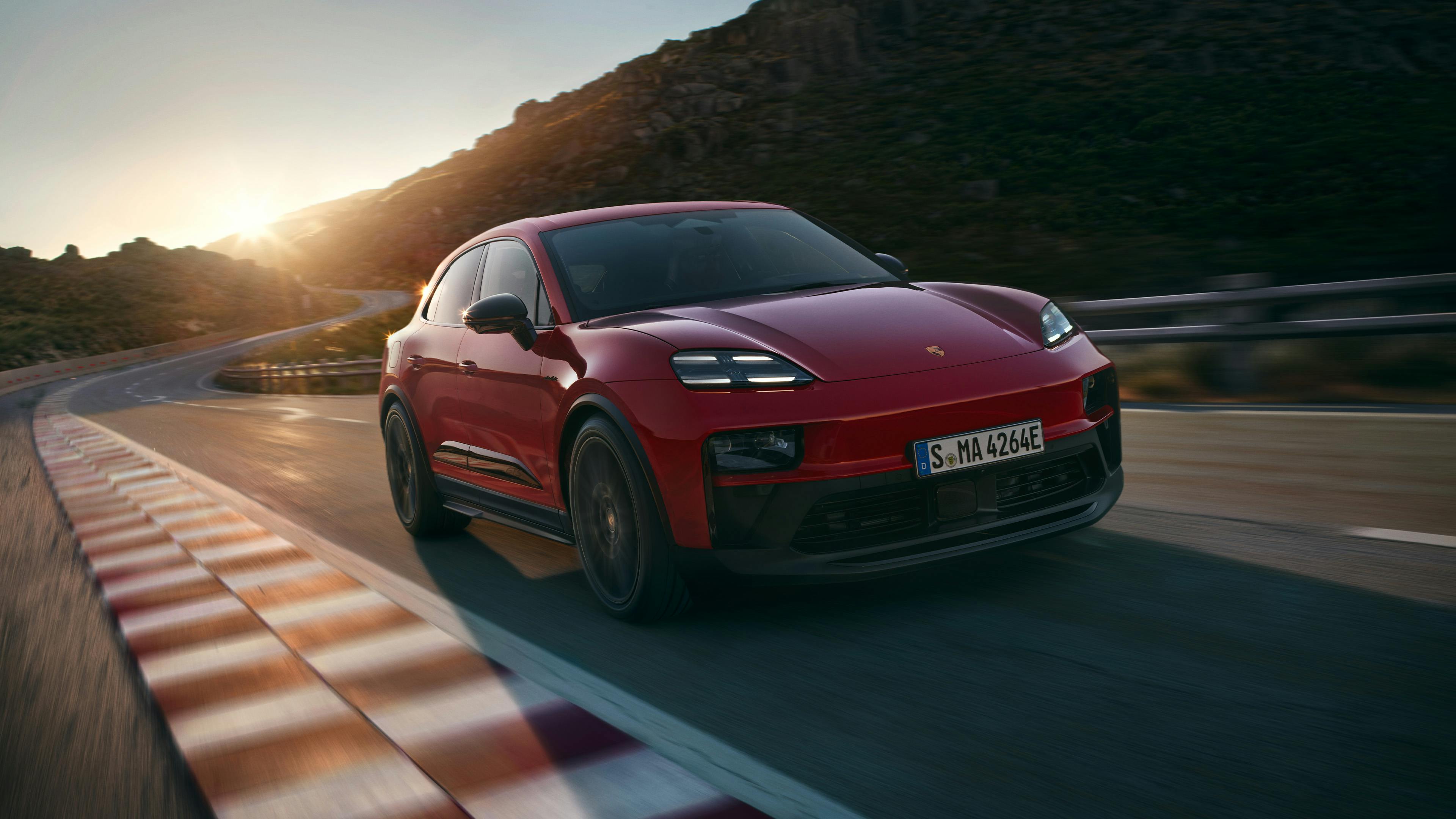 The new all-electric Macan GTS driving along a road.