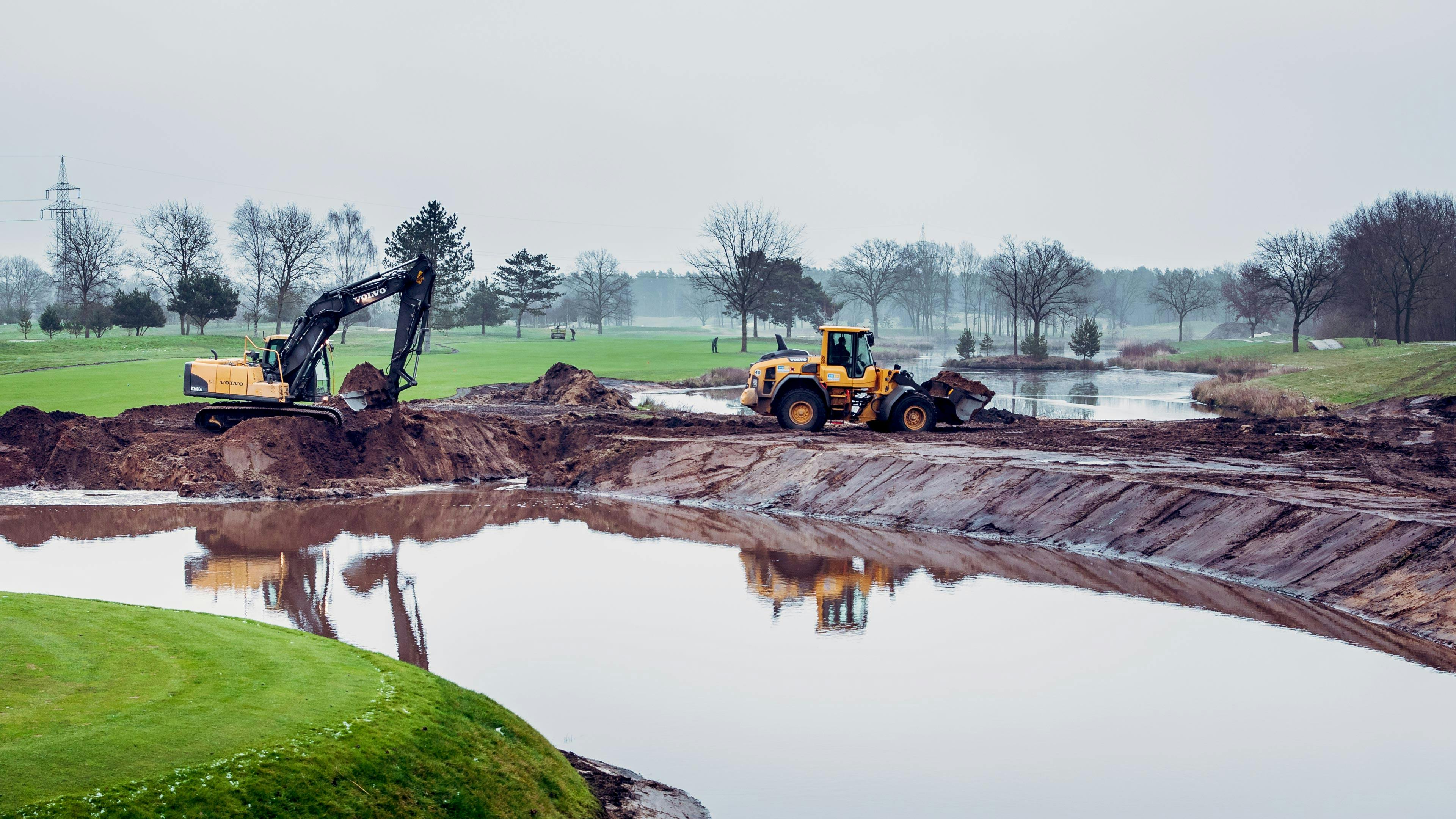 Umbau der Bahn 18 des Porsche Nord Course mit einem Wasserhindernis und einem Bagger am Bildrand