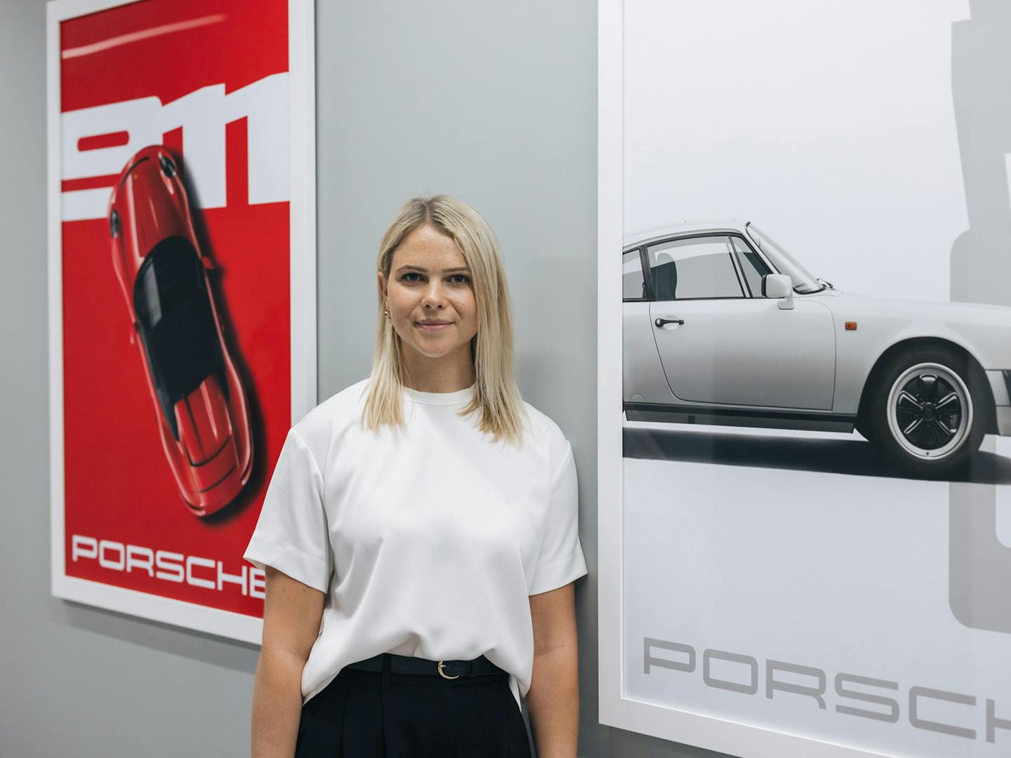 a woman standing infront of a wall with two posters