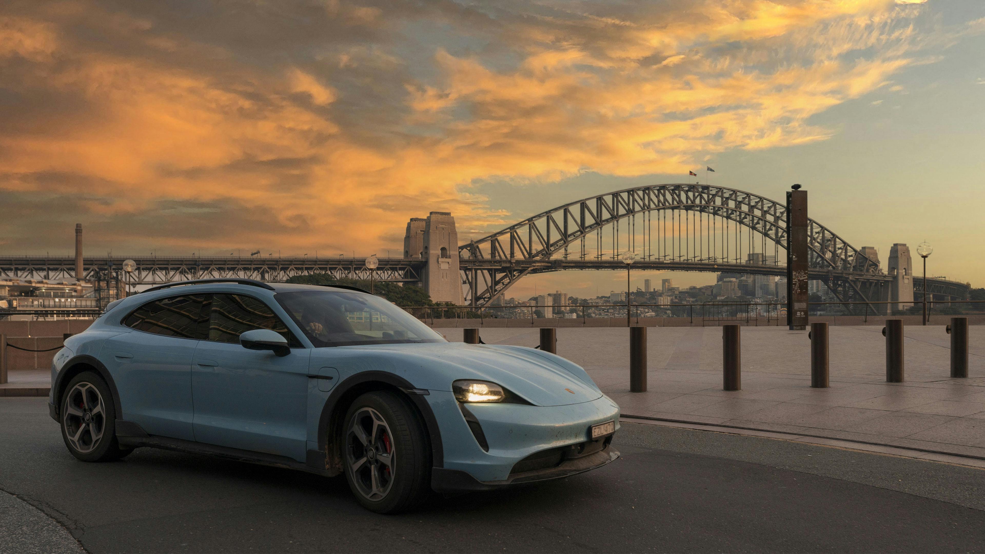 Porsche Taycan driving with Sydney Harbour Bridge in background