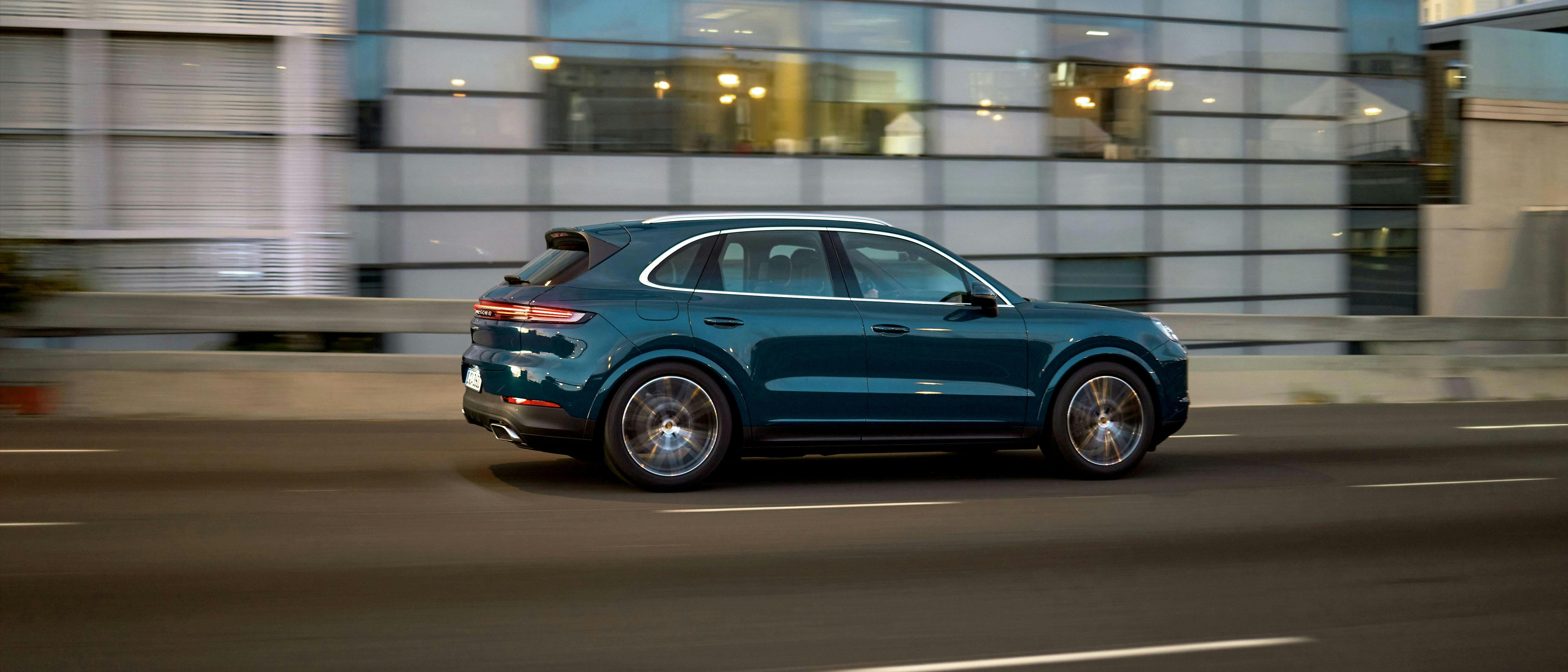 Blue Cayenne driving along highway