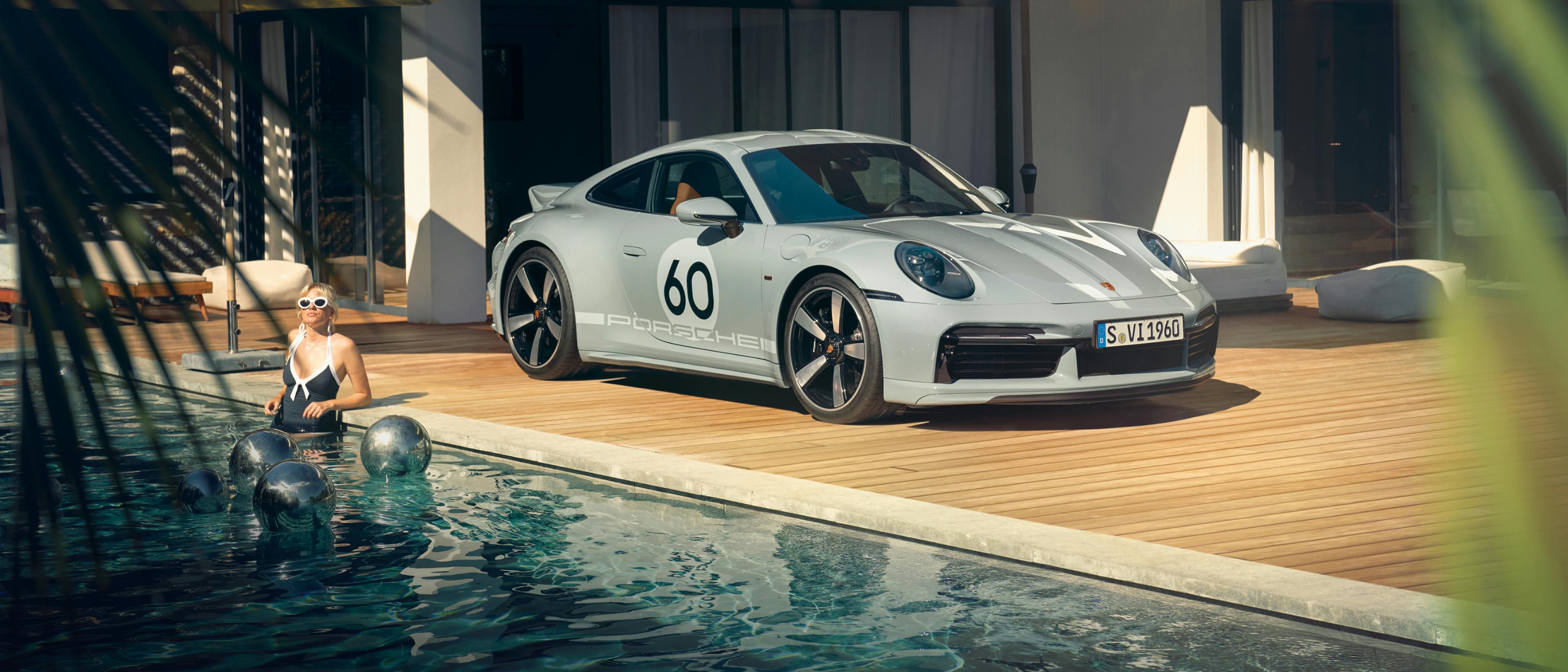 Porsche 911 Sport Classic in Sport Grey Metallic by the pool in front of a villa. Front and side views.