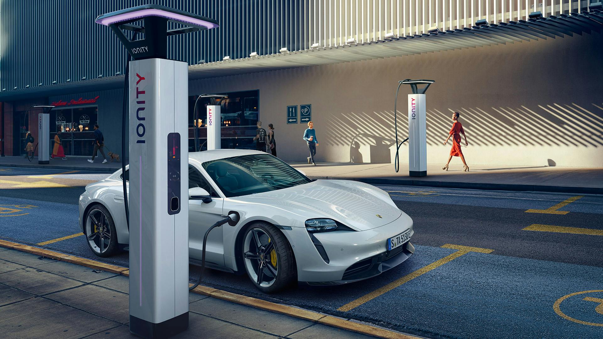 White Porsche Taycan connected to charging station.