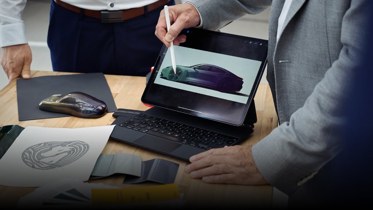 Adviesgesprek met Porsche Sonderwunsch met schets op tablet.