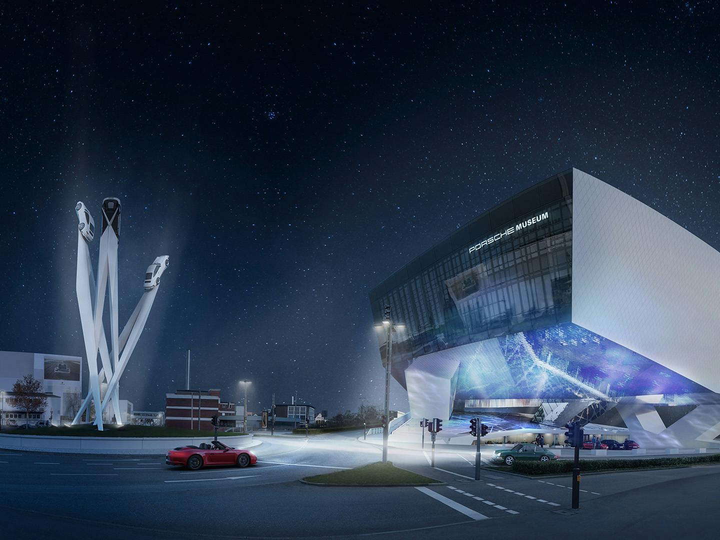 Porsche Museum bei Nacht mit beleuchteter, schwebender Architektur und Skulptur aus drei aufragenden Säulen mit Fahrzeugen, Sternenhimmel und vorbeifahrendem Sportwagen
