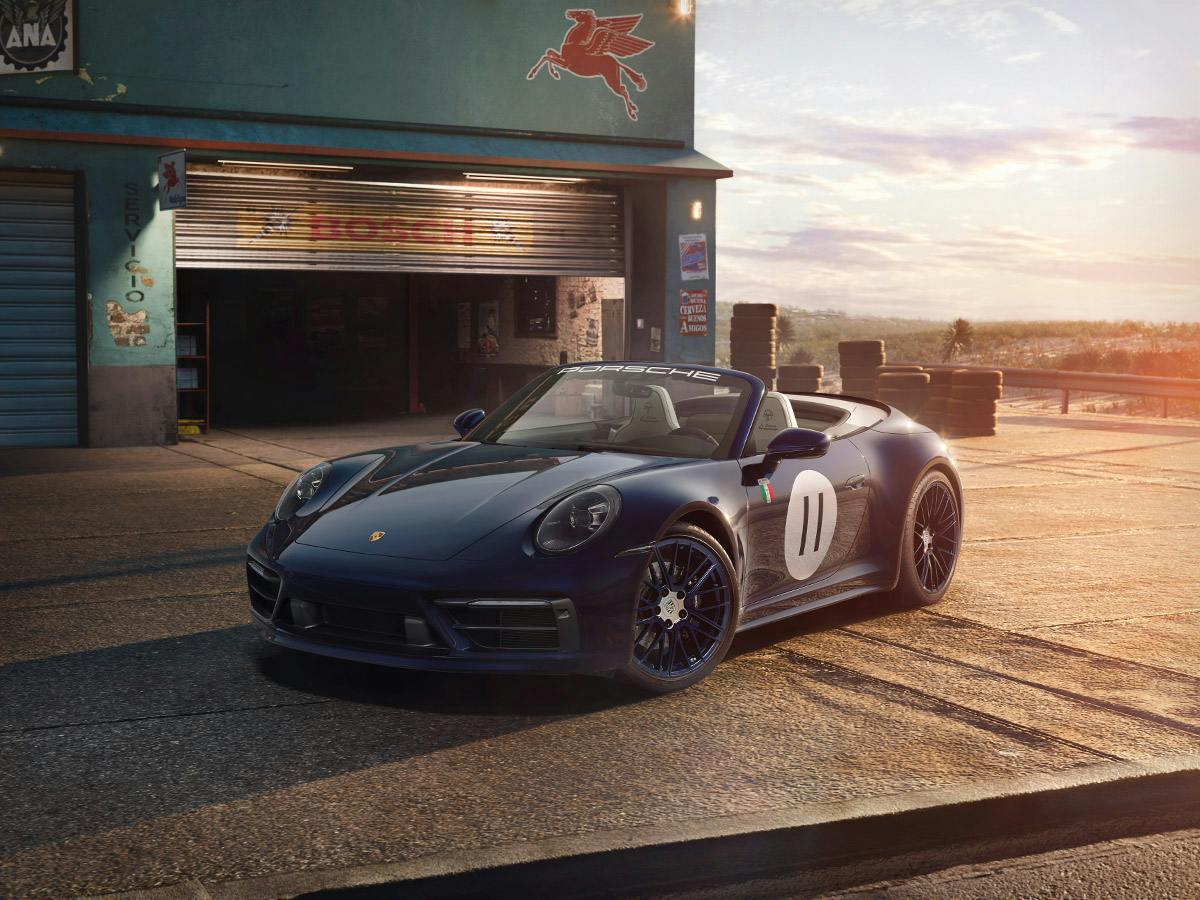 A 911 Carrera S (992) Panamericana Special coloured in Gentianbluemetallic and with the starting number 11 on the door with Cabriolet open in front of a store in the sunrise in a Mexican town.
