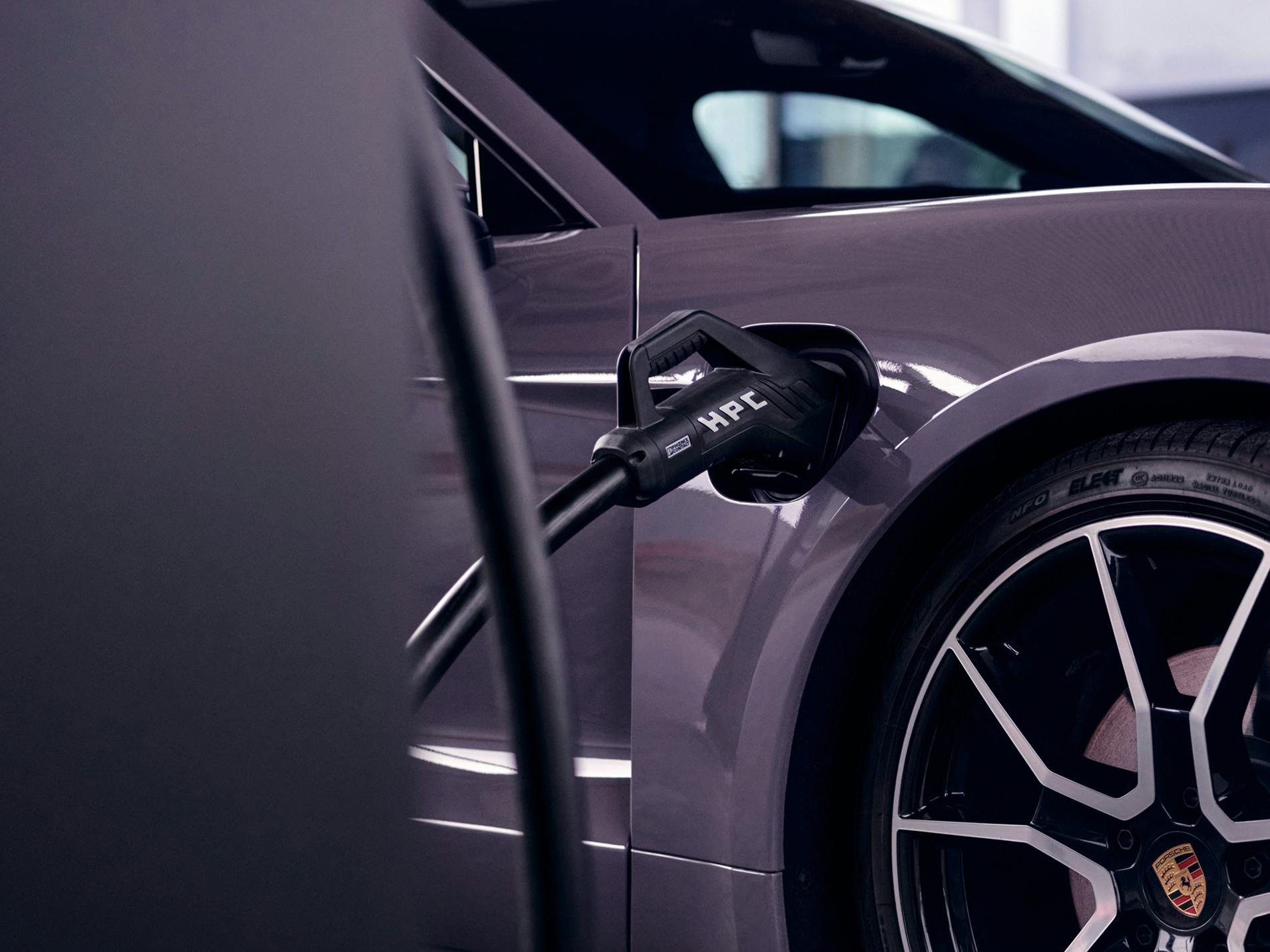 A charging plug labelled HPC plugged into the charging socket of a Porsche Taycan.
