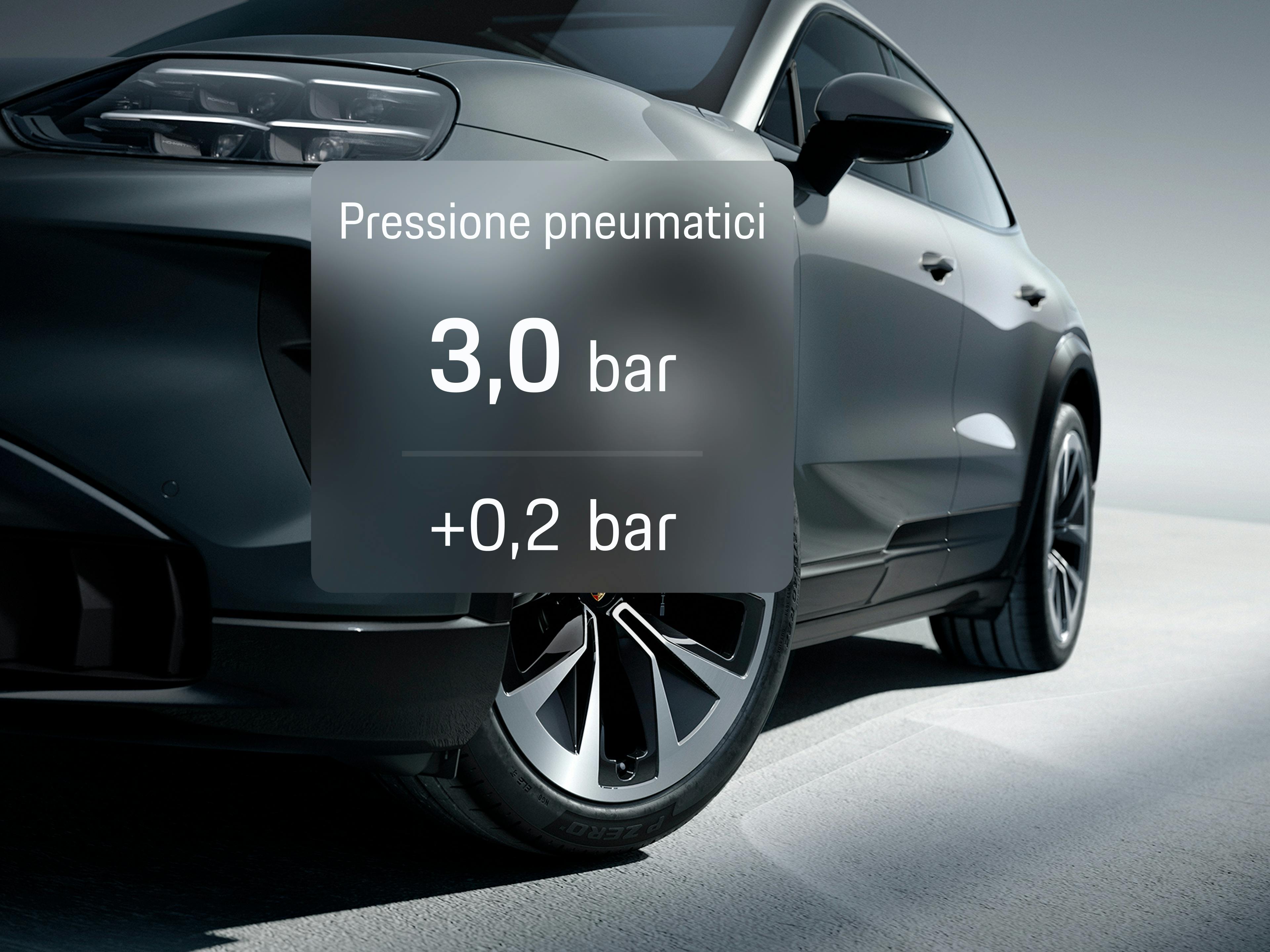 Primo piano di un SUV Porsche grigio con la pressione dei pneumatici sovrapposta sopra la ruota anteriore come parte della vista dell'app.