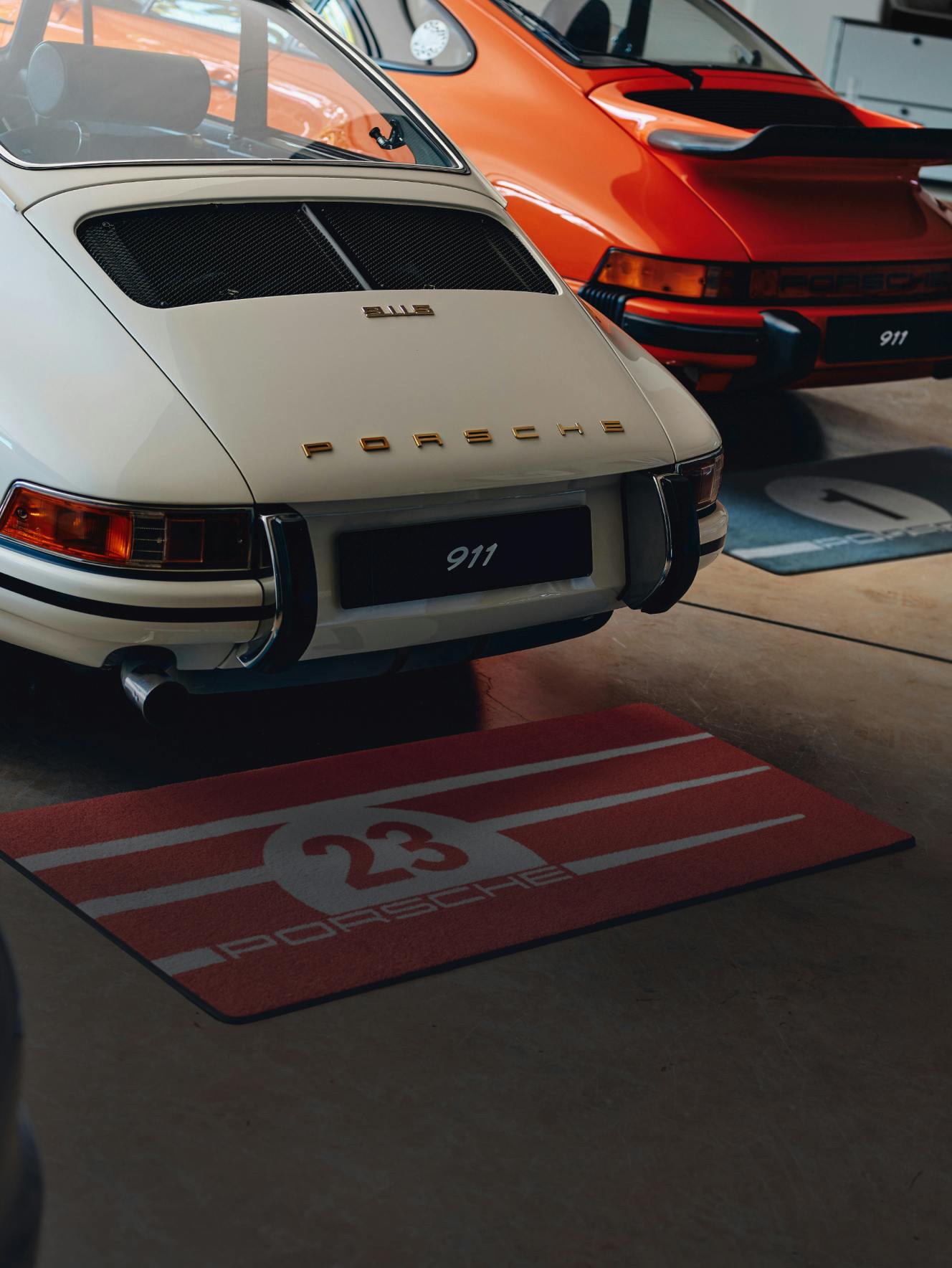 View of the rear end of two classic Porsche 911 models.