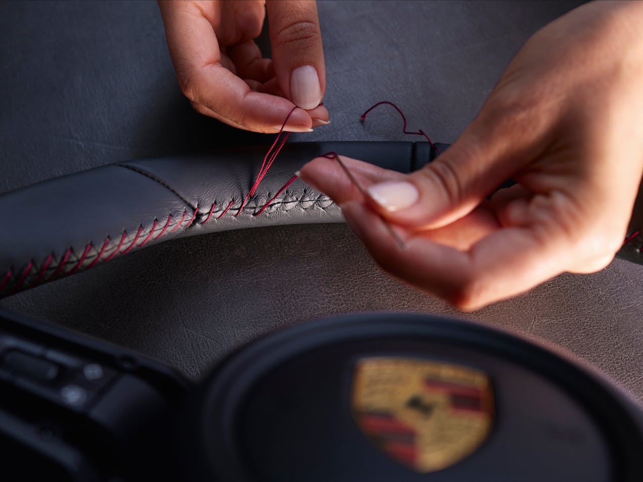 Bij een Porsche stuurwiel wordt het leder met de hand genaaid.
