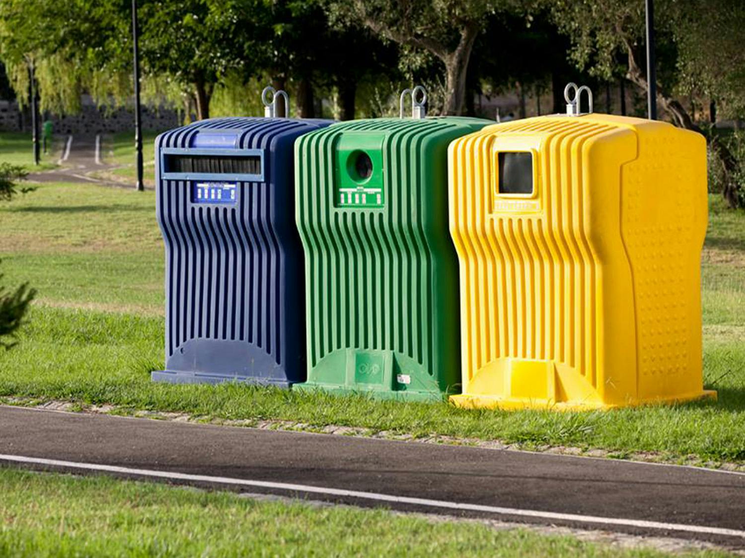 Ecoponto de reciclagem de lixo com três contentores nas cores azul, verde e amarelo.
