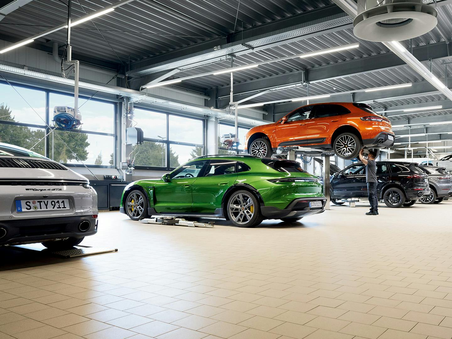 A Porsche service Centre with various models being serviced.