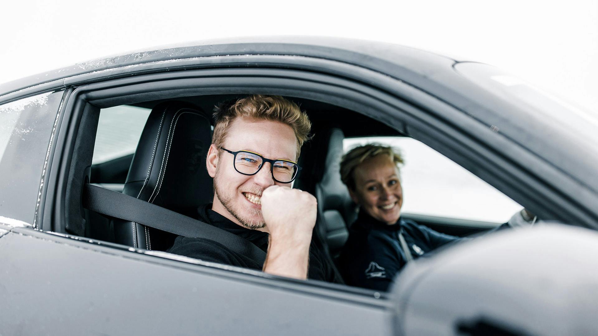 Two participants of the Porsche Ice Experience in Finland look out of their Porsche.
