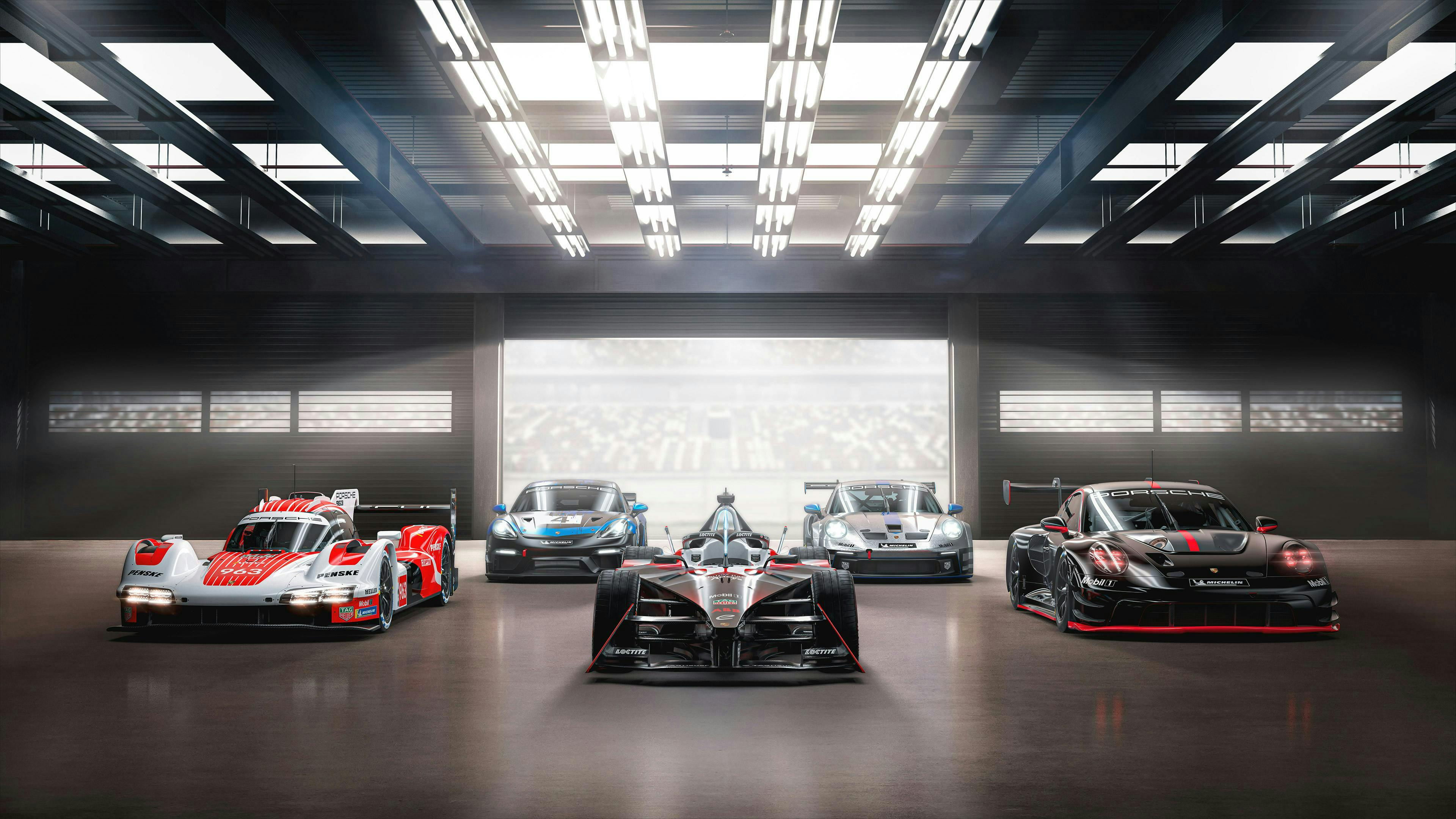 Porsche Motorsport Range Visual mit 5 Modellen der Jahre 2023/2024 sind frontal in einer Halle aufgereiht.
