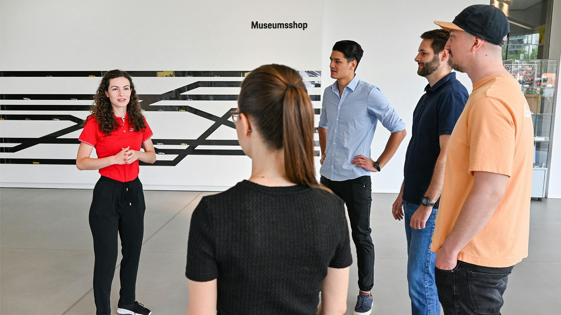 A group of pupils is welcomed to the museum by a member of staff.