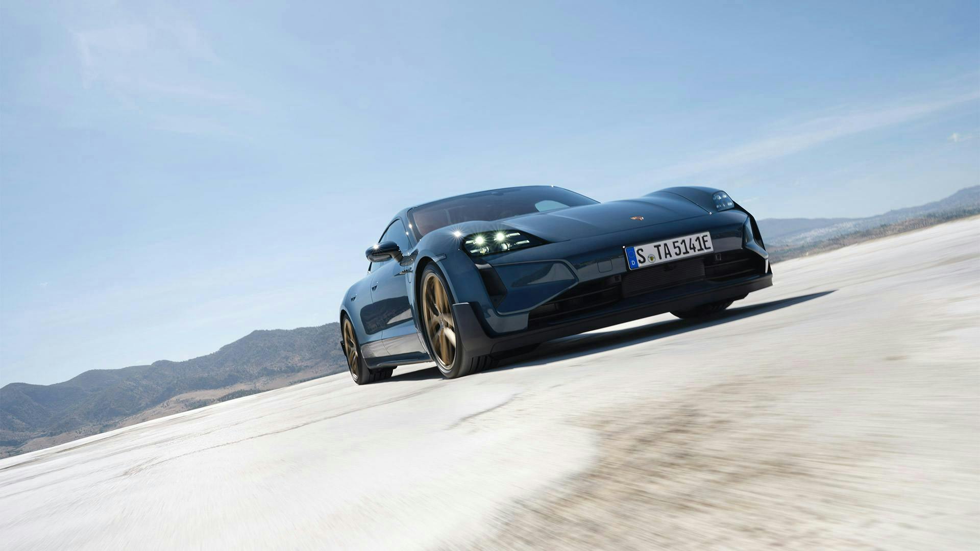 The Taycan Turbo GT driving across an open vast space.