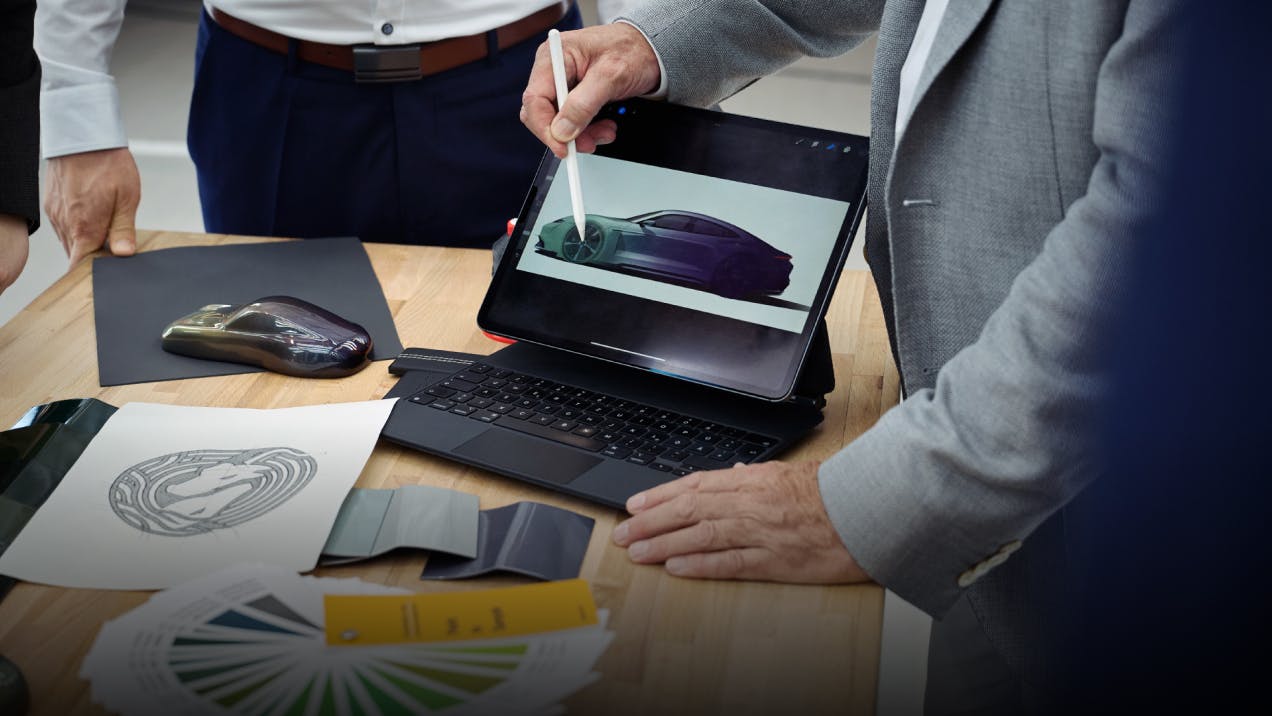 Adviesgesprek met Porsche Sonderwunsch met schets op tablet.