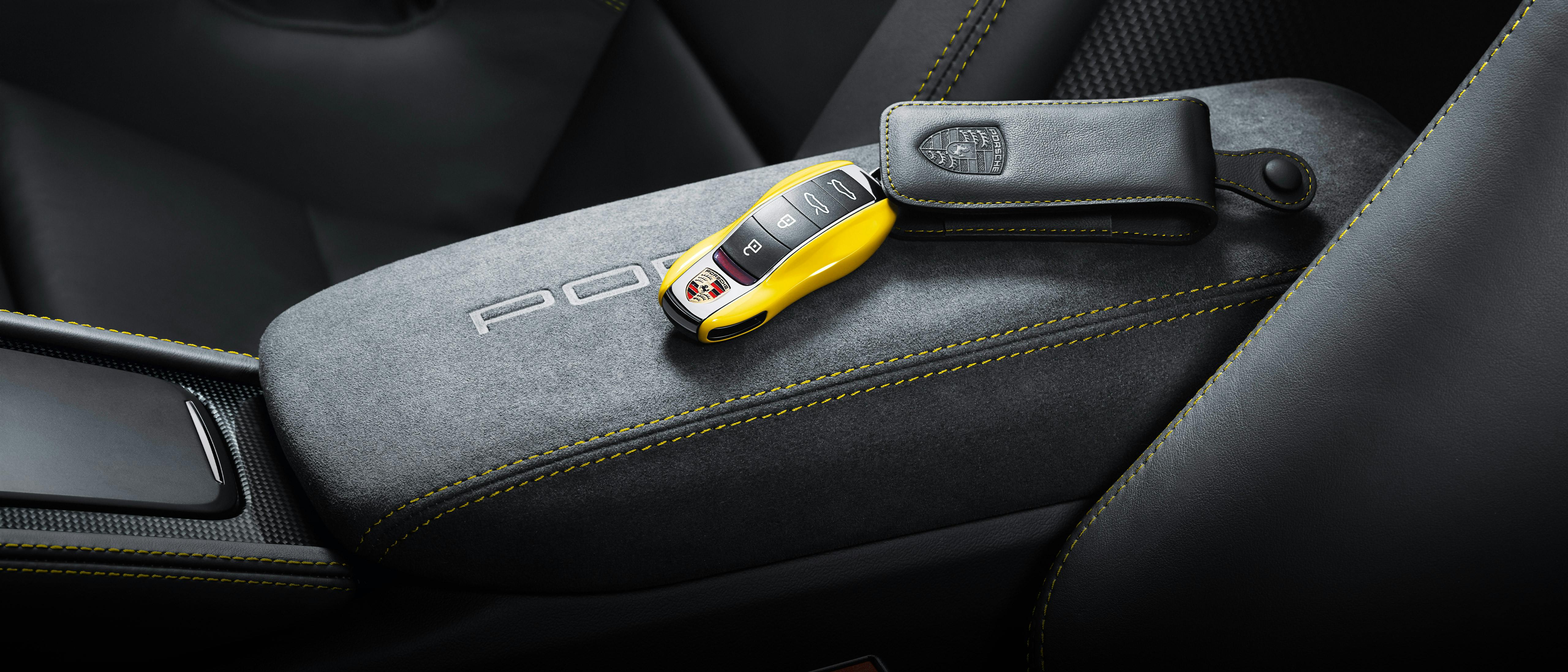 Une clé de véhicule Porsche laquée jaune se trouve sur la console centrale.